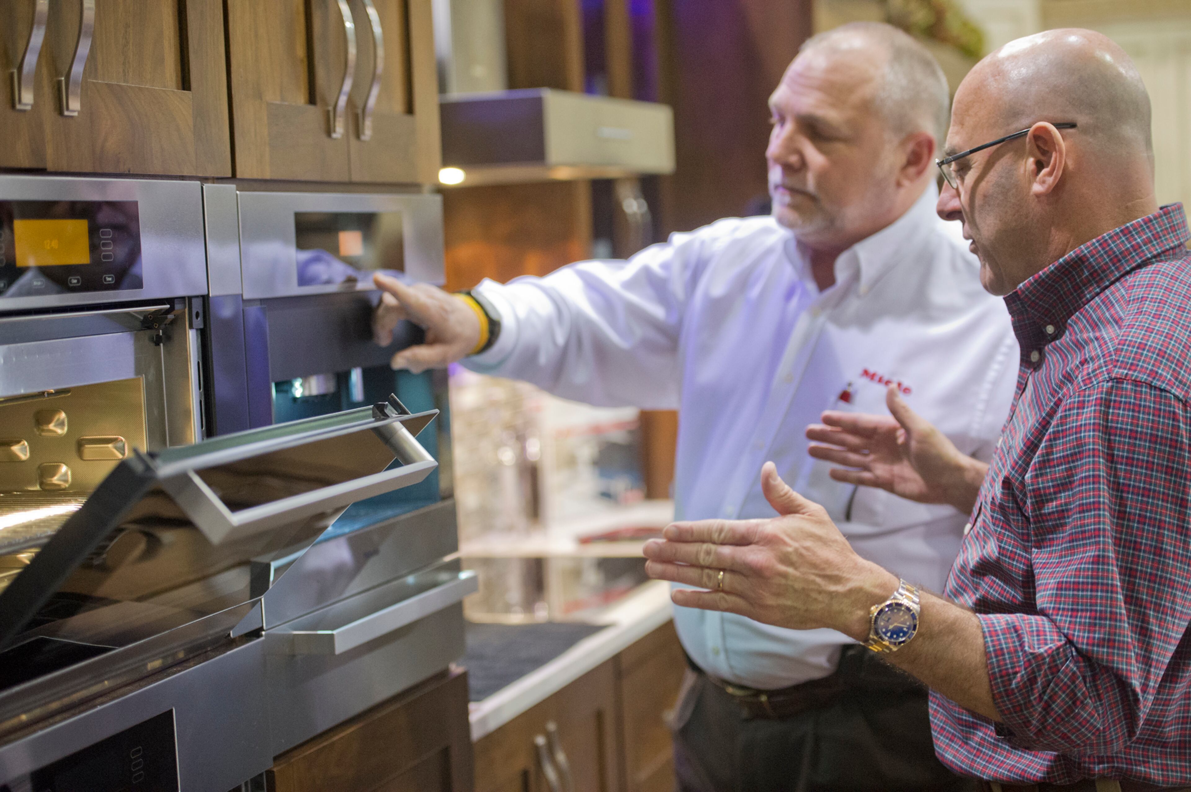 Brad Akins (right) talks with Jay Alvarez about different kitchen appliance options on display at the North Atlanta Home Show at the Gwinnett Center in Duluth on Feb. 23, 2014. In its 17th year, the show attracted 150 different home improvement companies. JONATHAN PHILLIPS / SPECIAL