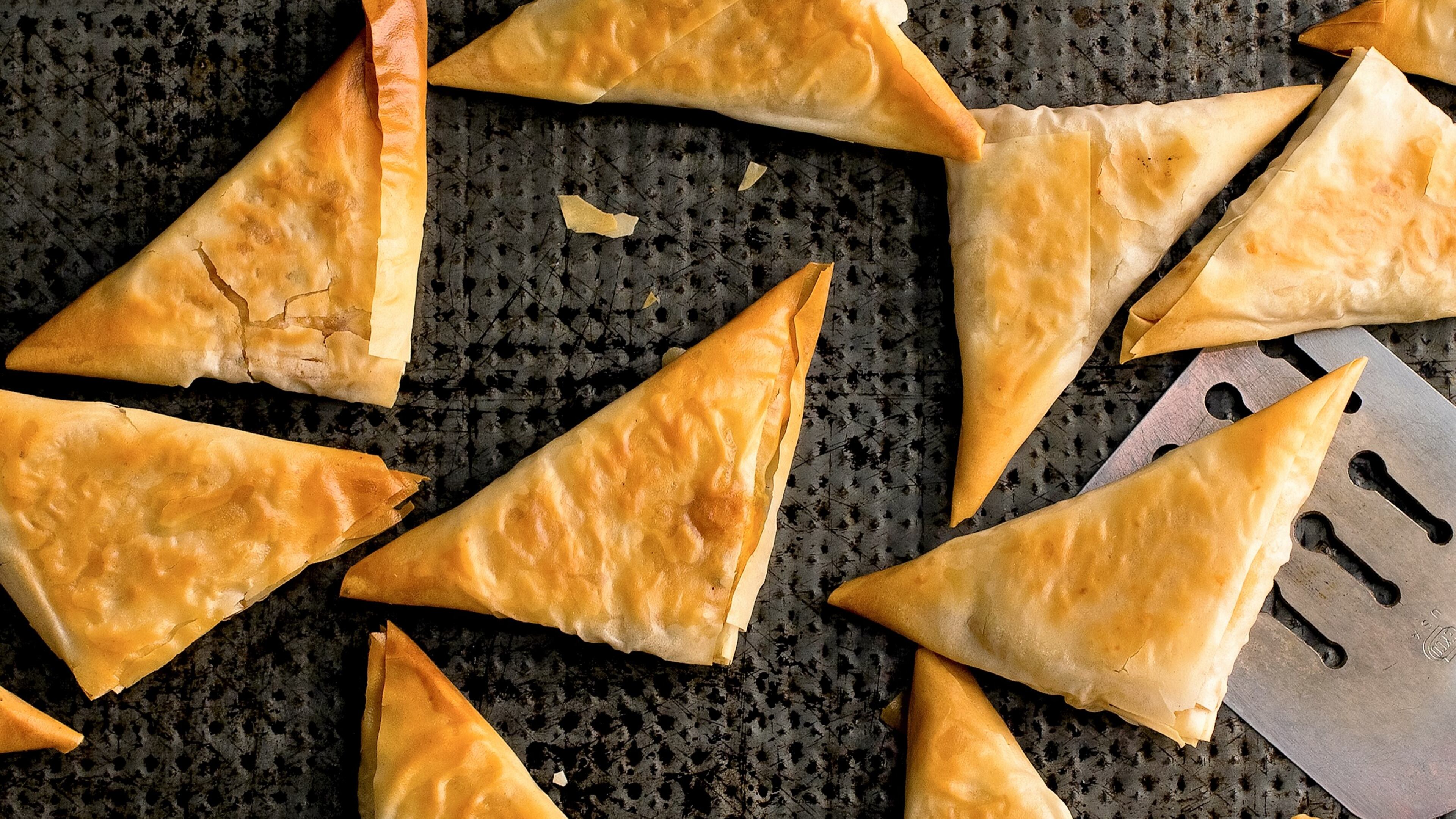 Baked Greek phyllo triangles filled with roast winter squash mixed with sauteed scallions and garlic, a generous amount of mint, feta and egg, in New York, Nov. 25, 2015. The crispy filled pastries are always impressive, and while they take some time to make, they are not at all difficult.