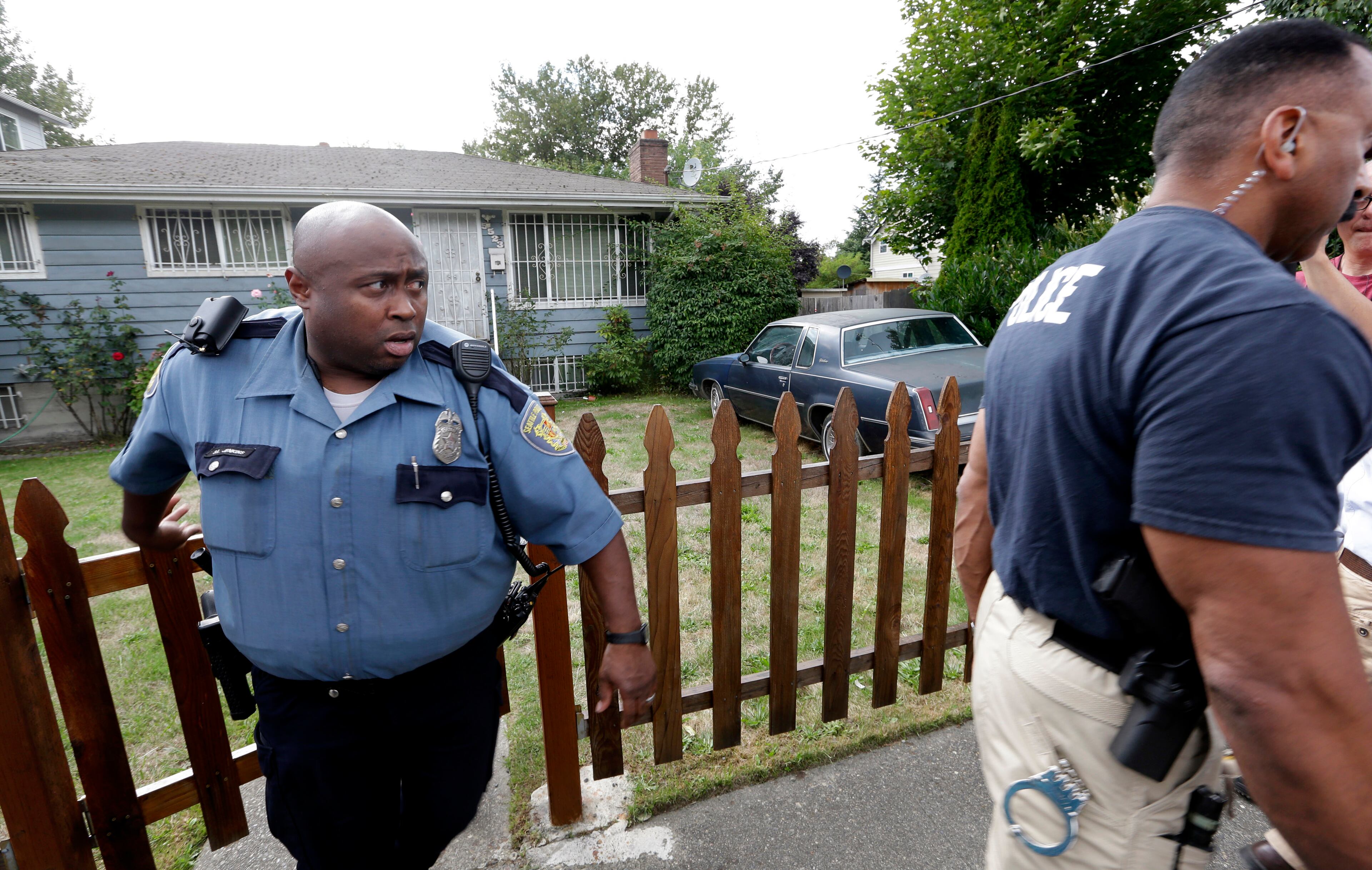 Seattle police officers depart the home of at least one relative of Aaron Alexis, the man identified as the shooter in the Washington Navy Yard shootings, after speaking with an occupant on Monday, Sept. 16, 2013, in Seattle. According to public documents, Alexis lived in Seattle at the home in 2004 and 2005. (AP Photo/Elaine Thompson)