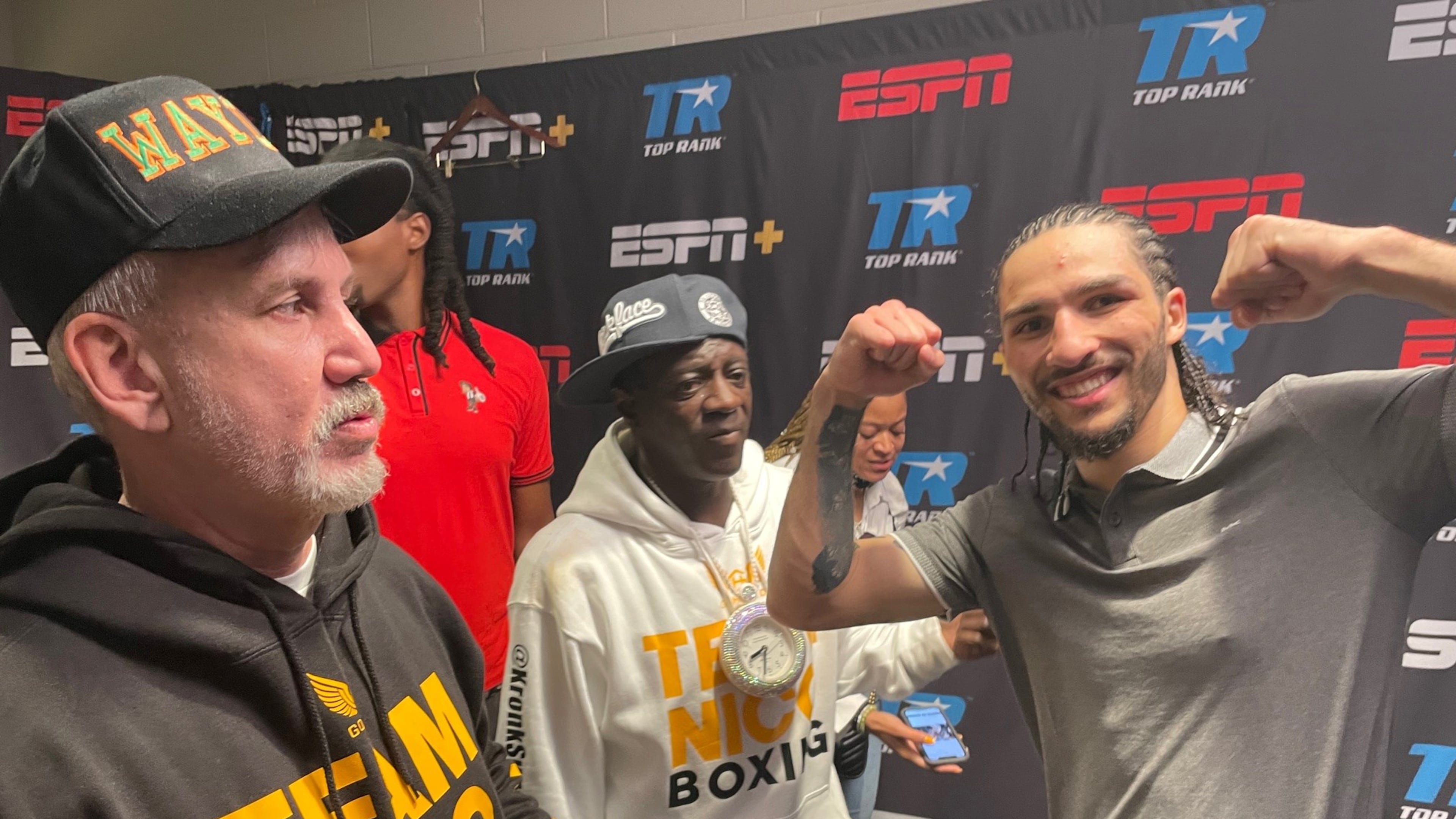 Nico Ali Walsh, the grandson of The Greatest, celebrates a victory in a dressing room at State Farm Arena with his uncle, Mike Joyce (left), and godfather, rapper Flavor Flav. (Photo by Bill Torpy)