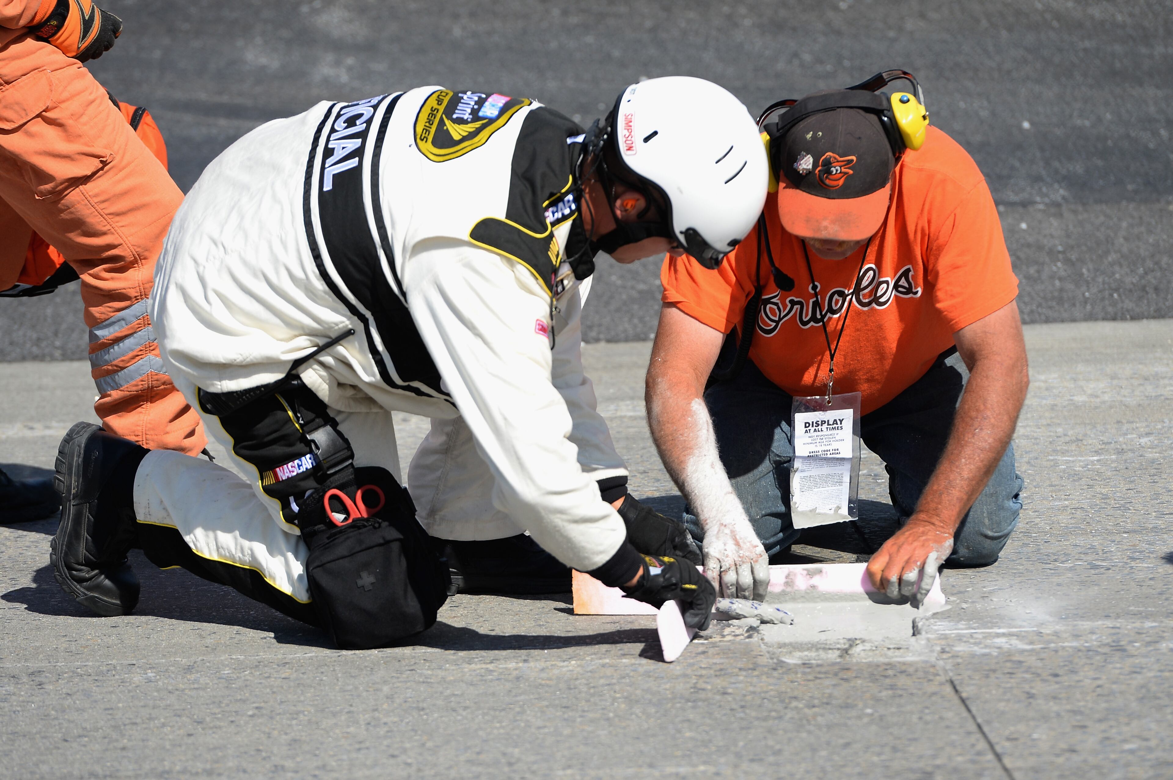 Workers patch a hole in the track going into the second turn during the NASCAR Sprint Cup Series FedEx 400 Benefiting Autism Speaks at Dover International Speedway on June 1, 2014 in Dover, Delaware. (Photo by Patrick Smith/Getty Images)