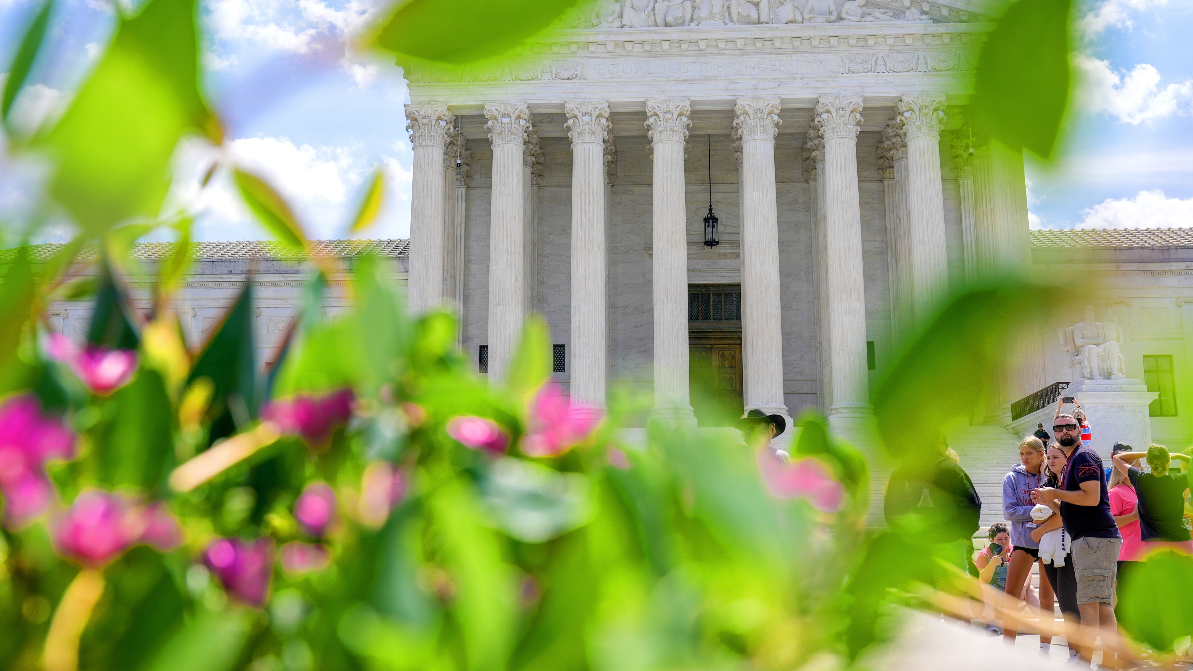 Visitors walk in front of the Supreme Court Friday, July 24, 2026, in Washington. (AP Photo/Mariam Zuhaib)