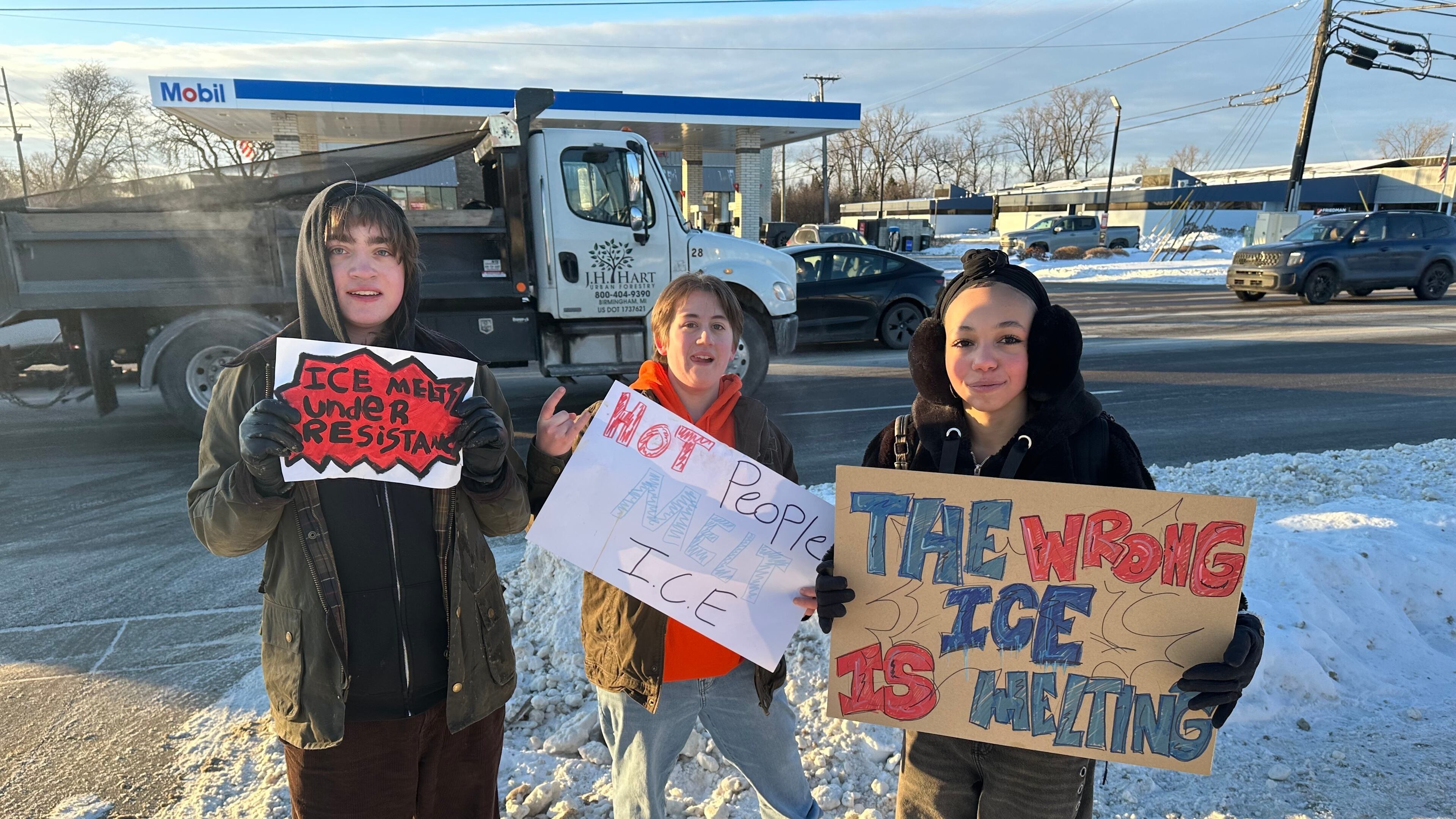 From left, Asher O'Donnel, Ryan Maddox and Amari Perez-Wayner hold signs as several dozen Groves High School students who walked out of morning class on Friday, Jan. 30, 2026 in Birmingham, Mich. (AP Photo/Corey R. Williams)
