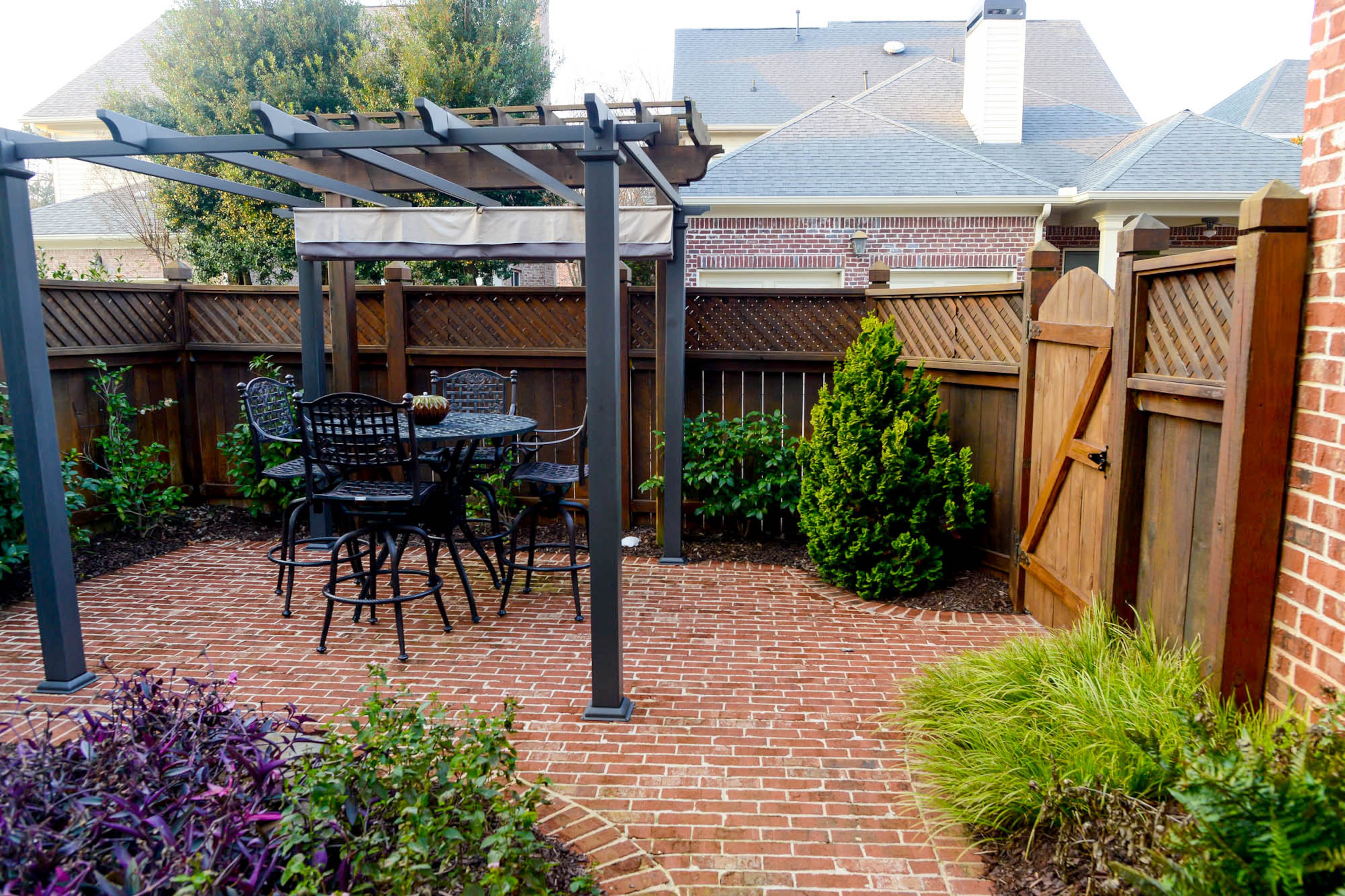The Callahans included the courtyard in their renovations by working with landscaper Scott Tolbert, who removed overgrown bushes and trees to create more room for outdoor entertaining. The area now includes a dining space beneath a pergola. Christopher Oquendo/AJC FILE