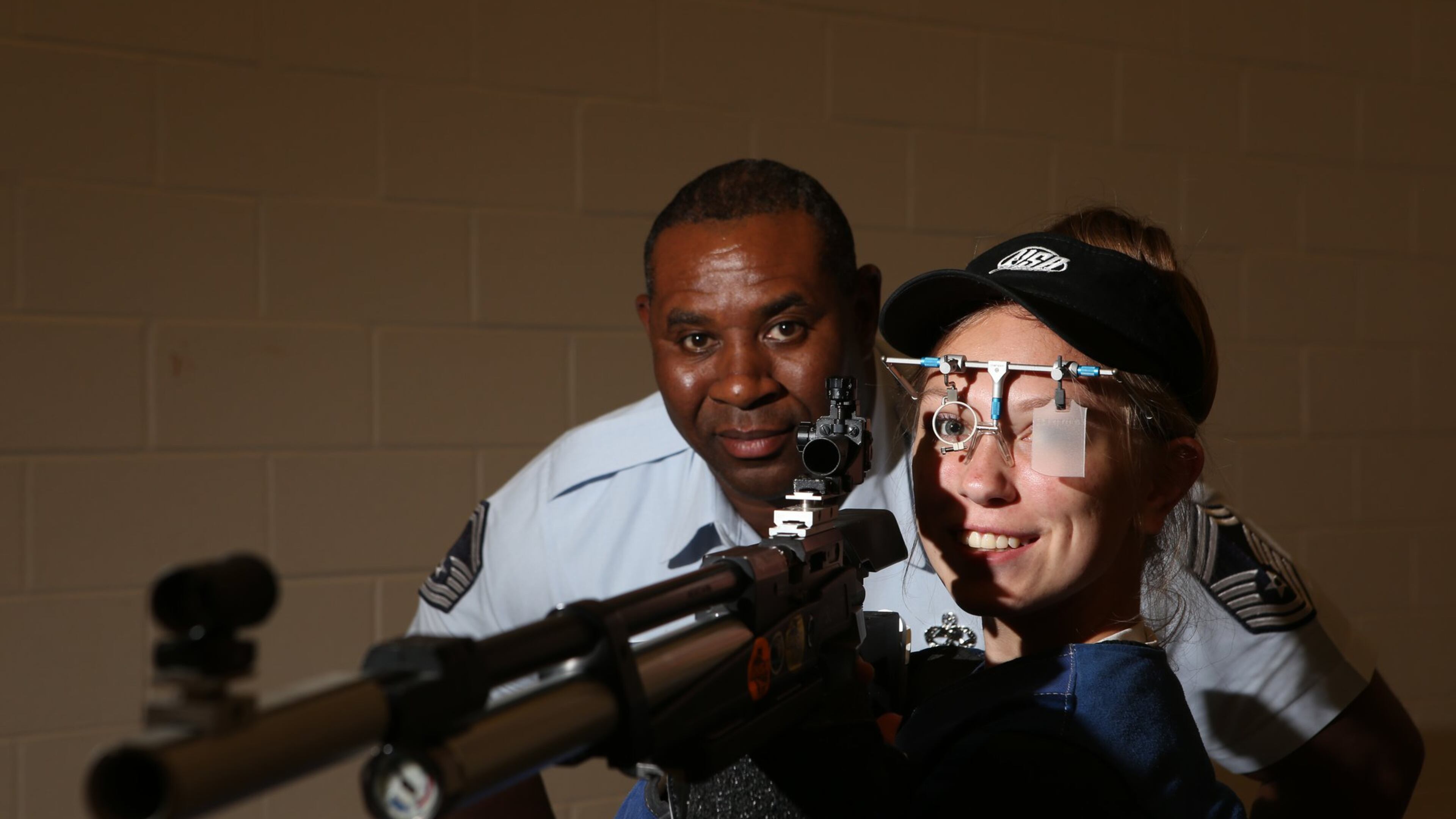 Rayven Fincher, 16 (right), a sophomore at Monroe Area High School, poses with her competition air rifle and Air Force JROTC SMSgt. Clay Slaton at their indoor training facility in Monroe, Georgia, on May 2, 2017. Fincher took the state champion title at “The Dixie Double” at Fort Benning and only missed qualifying for the Junior Olympics by one point. After breaking her spine in a car accident last year and losing nearly six months of practice time, her trajectory is unmatched, and she hopes to continue it and qualify for the Olympics one day. (HENRY TAYLOR / HENRY.TAYLOR@AJC.COM)
