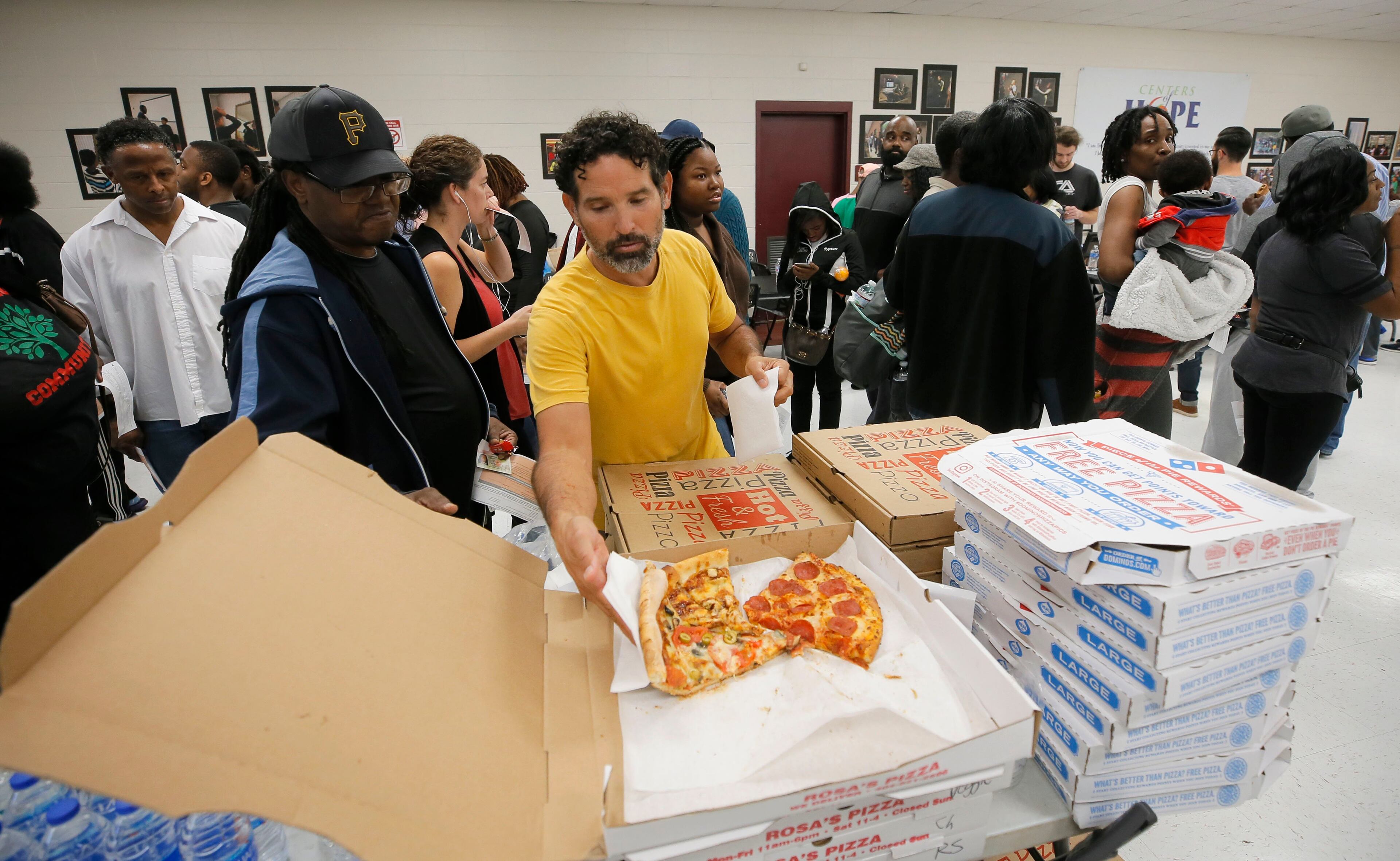 11/6/18 - Atlanta - Angel Poventud, who voted early, volunteers his time to hand out pizza and snacks to people waiting in line. The wait time to vote at the Pittman Park precinct in Atlanta was reported to be three hours. Pizza and snacks were donated for the people waiting in line. BOB ANDRES / BANDRES@AJC.COM