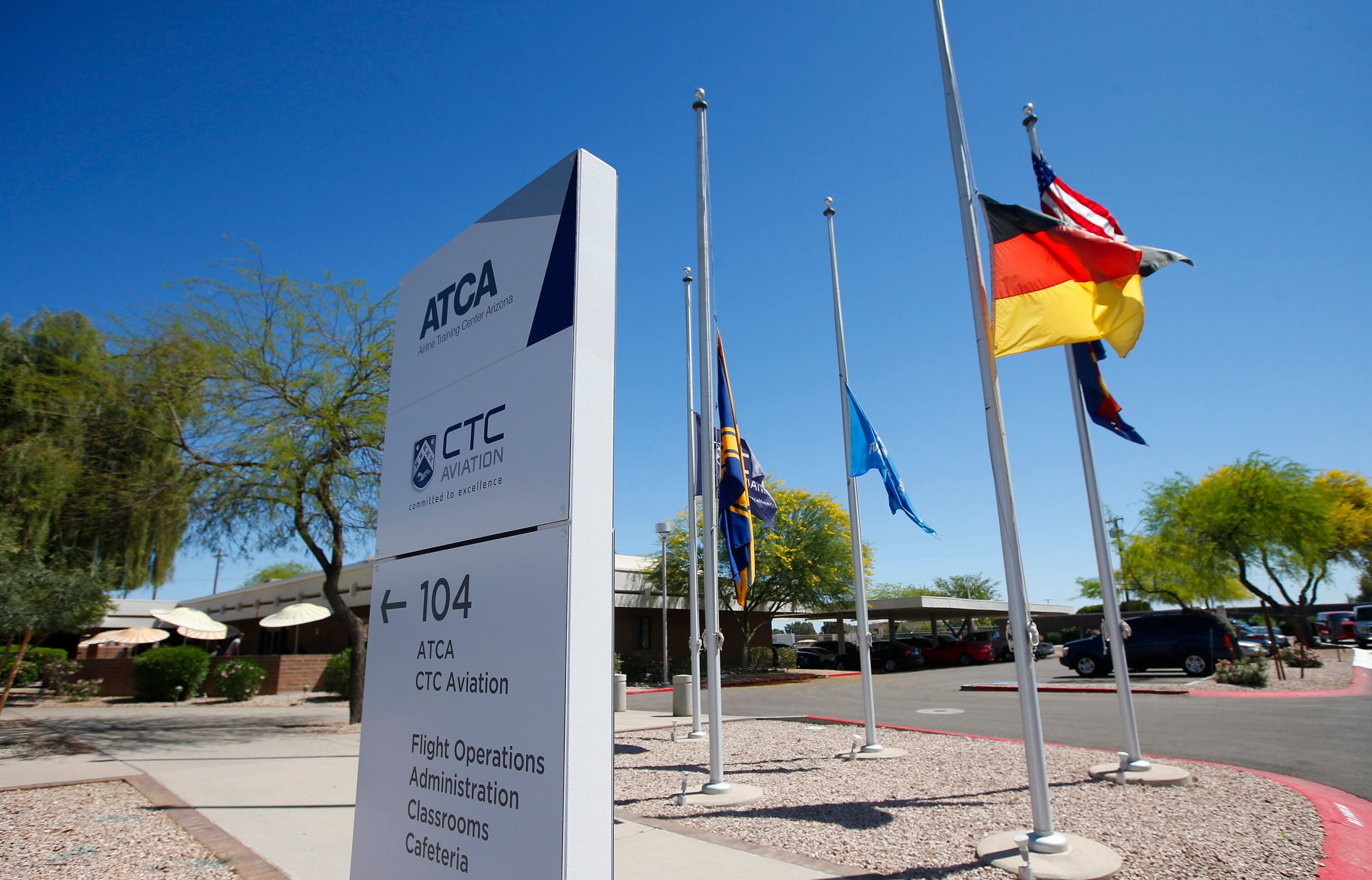 Several flags, including the German flag, fly at half staff at The Airline Training Center Arizona Thursday, March 26, 2015 at the Goodyear Airport in Goodyear, Ariz. German Pilot Andreas Lubitz, the co-pilot on Germanwings 9525 that crashed with 150 people on board on Tuesday in the French Alps, trained at the Airline Training Center in 2008 according to Lufthansa CEO Carsten Spohr. (AP Photo/Ross D. Franklin)