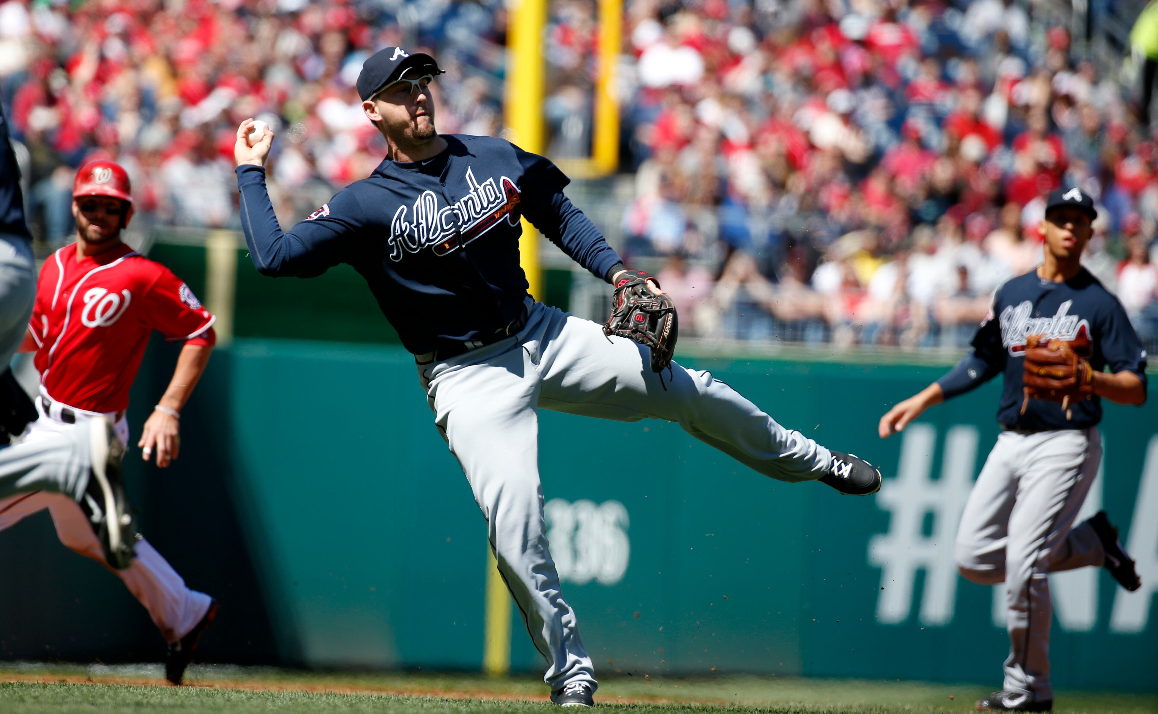 Atlanta Braves third baseman Chris Johnson makes a throw to first for an out against Washington Nationals' Ian Desmond during the first inning of a baseball game at Nationals Park, Sunday, April 6, 2014, in Washington. The play was reviewed and the out was confirmed. (AP Photo/Alex Brandon)