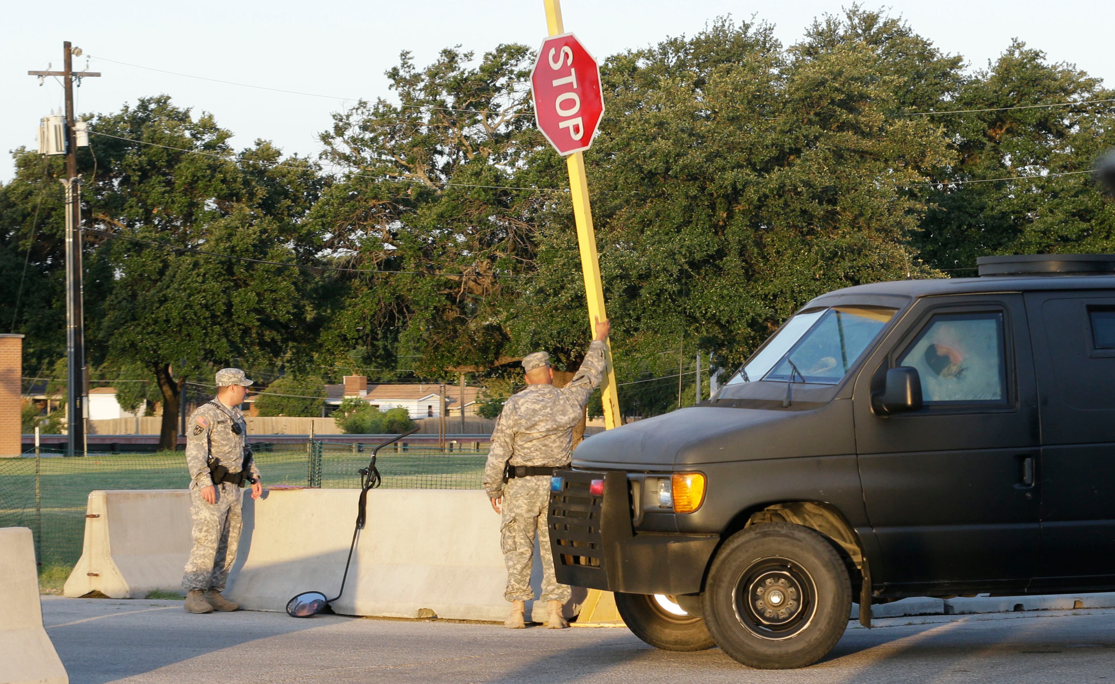 A U.S. solider checks a vehicle entering the courthouse parking lot where the court-martial of Maj. Nidal Hasan is beginning on Tuesday, Aug. 6, 2013, at Fort Hood. After years of delays, the trial of the man accused of carrying out the Fort Hood shooting is starting, with Hasan representing himself against charges of murder and attempted murder for the 2009 attack that left 13 people dead on the Army post.