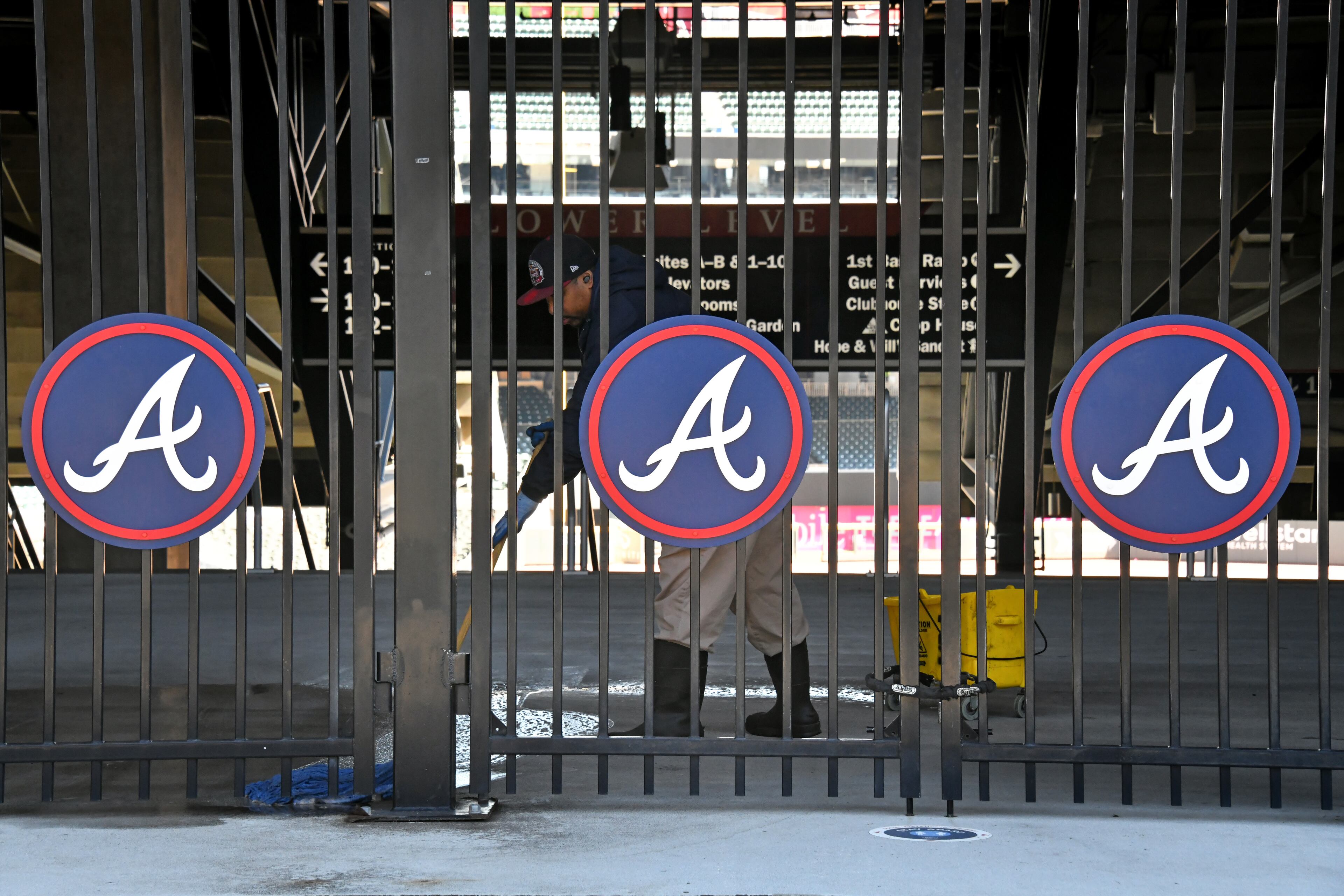 A cleaning crew member mops the floor near the first-base gate at Truist Park on Wednesday, March 2, 2022. (Hyosub Shin / Hyosub.Shin@ajc.com)