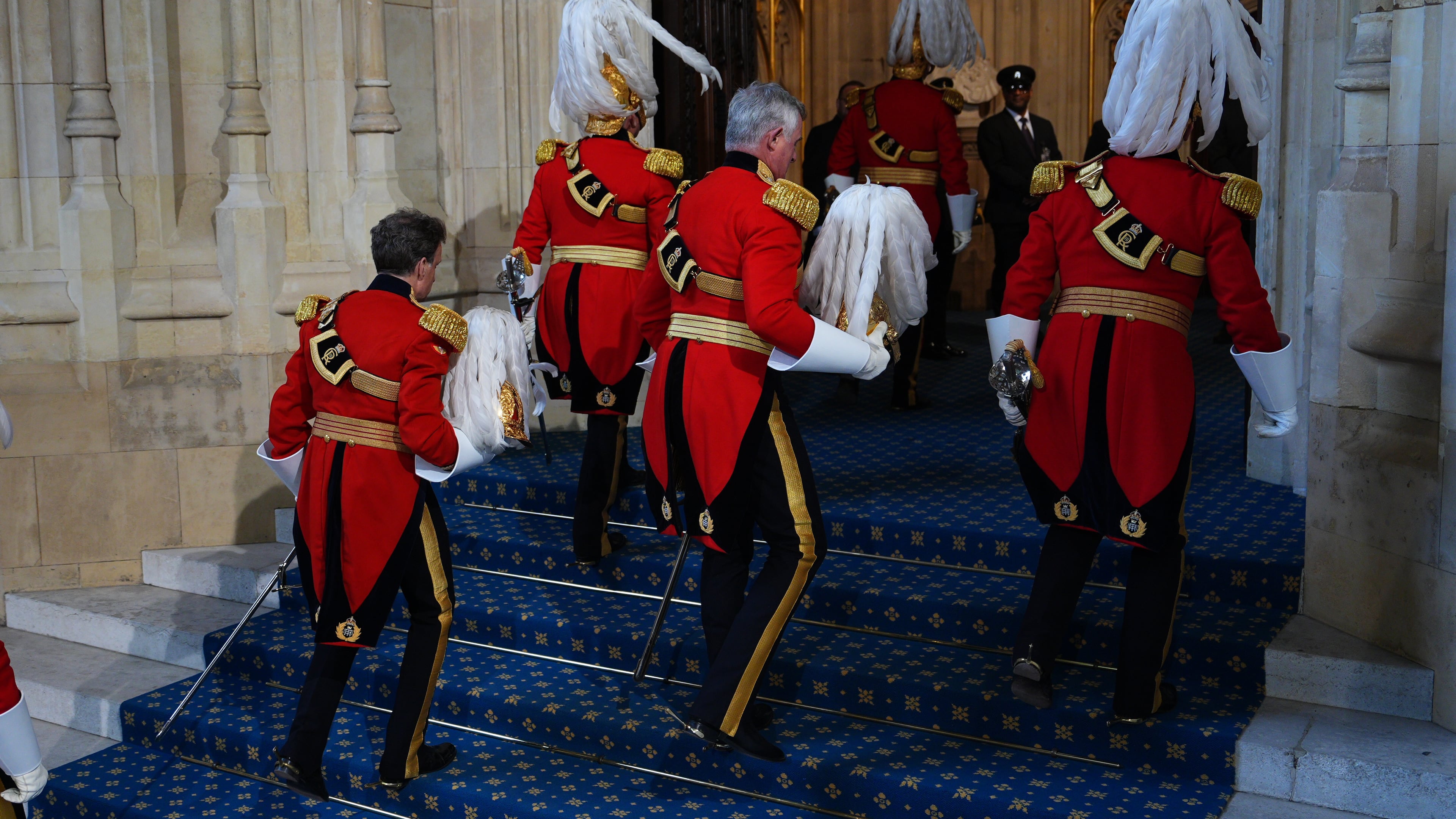 Members of the King's Body Guards of the Honourable Corps of Gentlemen at Arms arrive at the Sovereign's Entrance for the State Opening of Parliament in the House of Lords, in London, Wednesday May 13, 2026. (Aaron Chown/Pool Photo via AP)