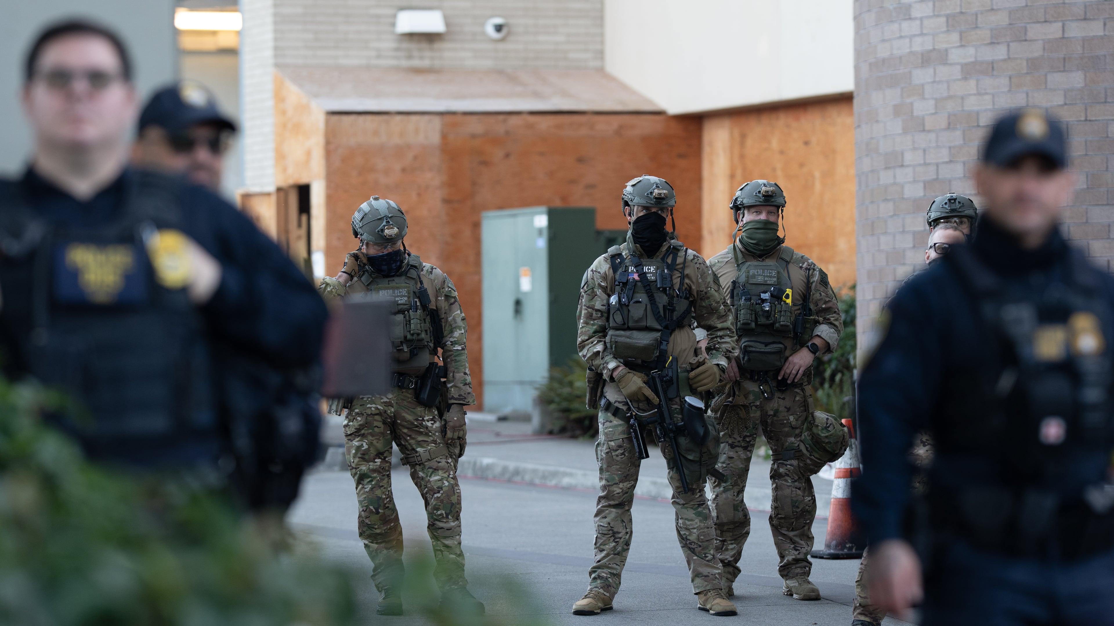 FILE - Law enforcement officers look out from a United States Immigration and Customs Enforcement (ICE) facility Oct. 21, 2025, in Portland, Ore. (AP Photo/Jenny Kane, File)