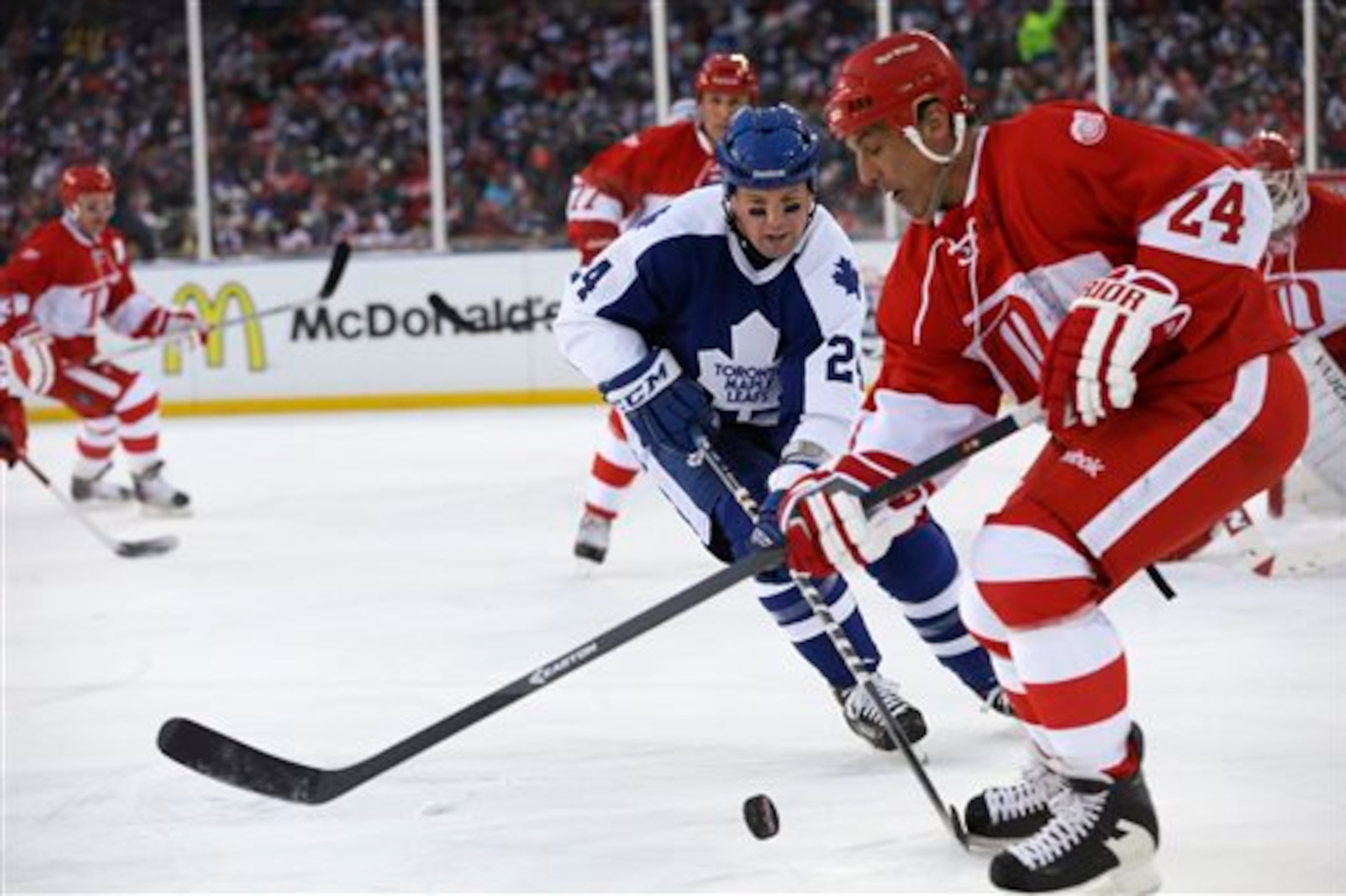 Toronto Maple Leafs defenseman Bryan McCabe closes in on Detroit Red Wings defenseman Chris Chelios during the first period of the Winter Classic alumni outdoor NHL hockey game at Comerica Park in Detroit, Tuesday, Dec. 31, 2013. (AP Photo/Carlos Osorio)