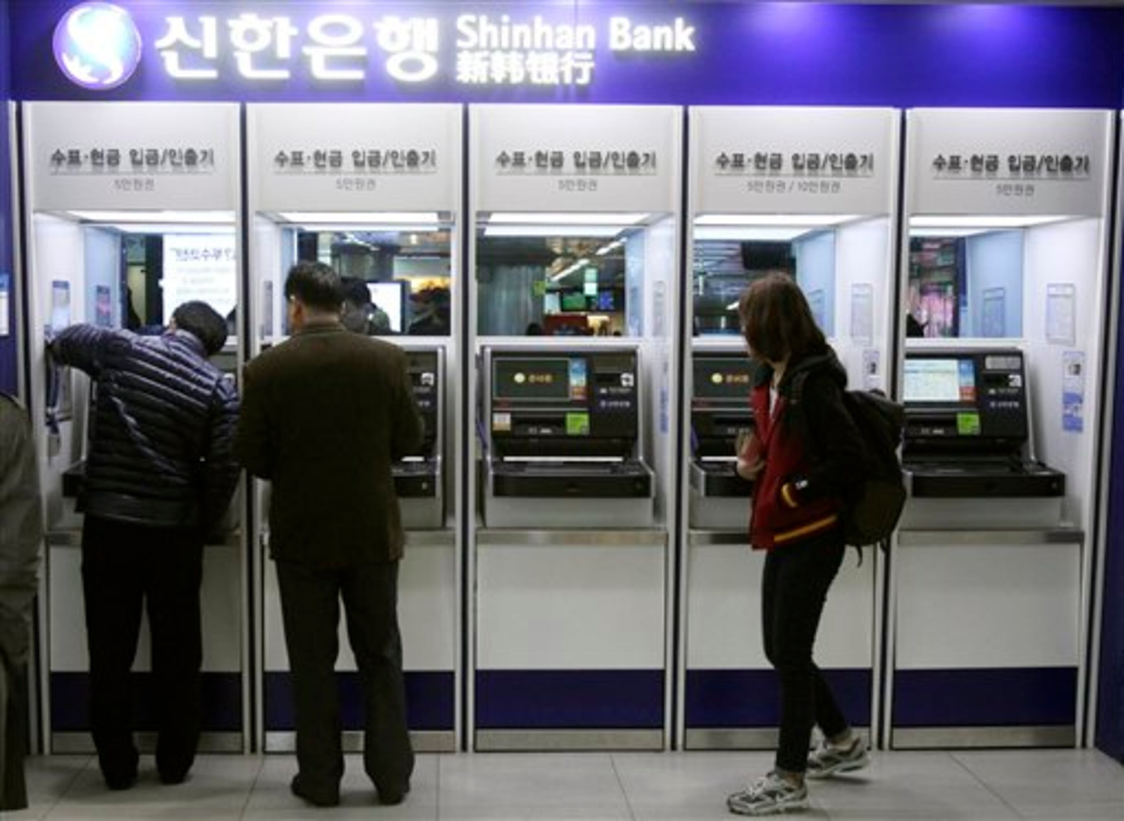 Depositors try to use automated teller machines of Shinhan Bank while the bank's computer networks are paralyzed at a subway station in Seoul, South Korea, Wednesday, March 20, 2013. Computer networks at two major South Korean banks and three top TV broadcasters went into shutdown mode en masse Wednesday, paralyzing bank machines across the country and prompting speculation of a cyberattack by North Korea. (AP Photo/Ahn Young-joon)
