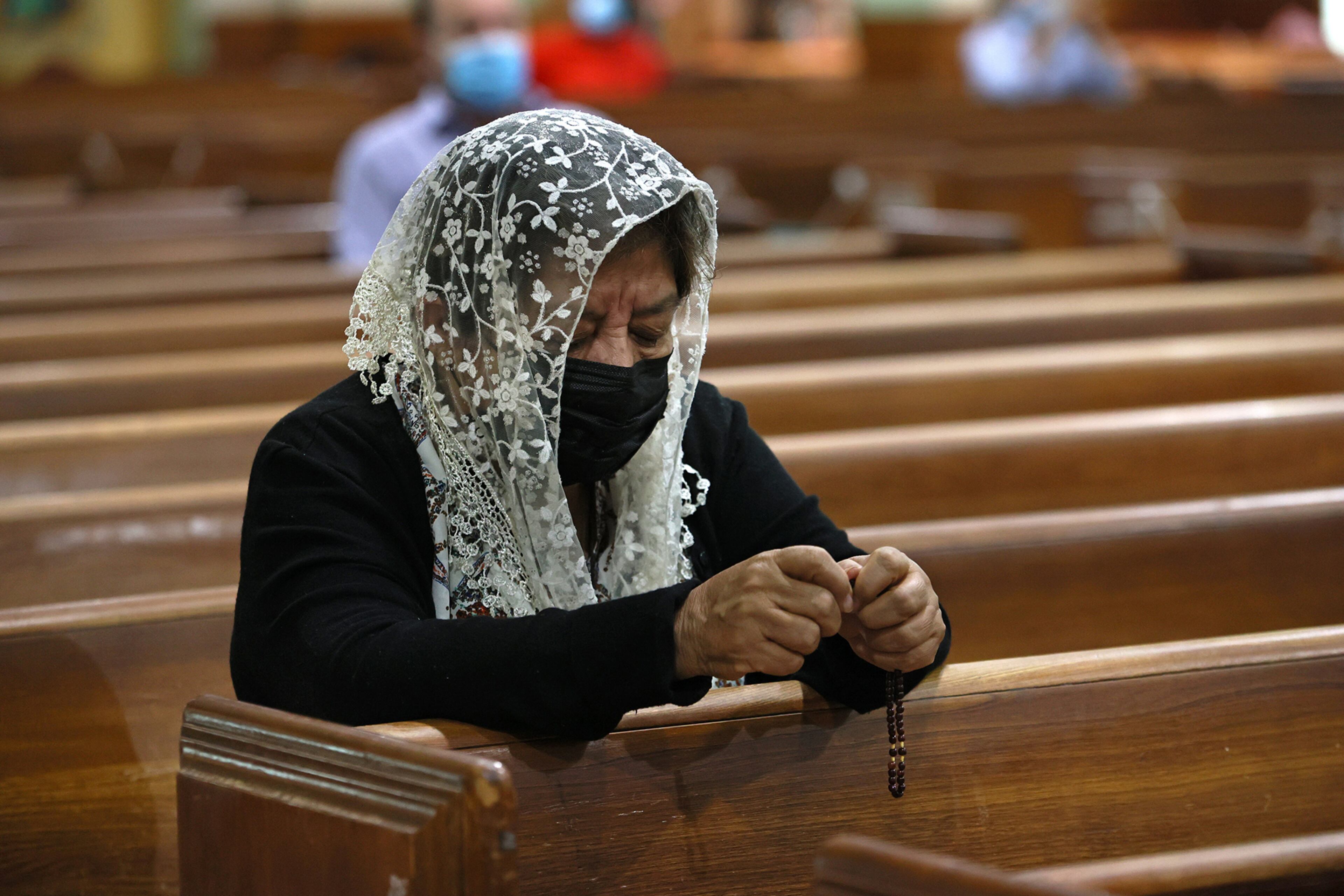 Sonia Rivas prays during Sunday mass at St. Josephís catholic church in Miami Beach on June 27, 2021. The apartment building partially collapsed on Thursday, June 24. (David Santiago/Miami Herald/TNS)