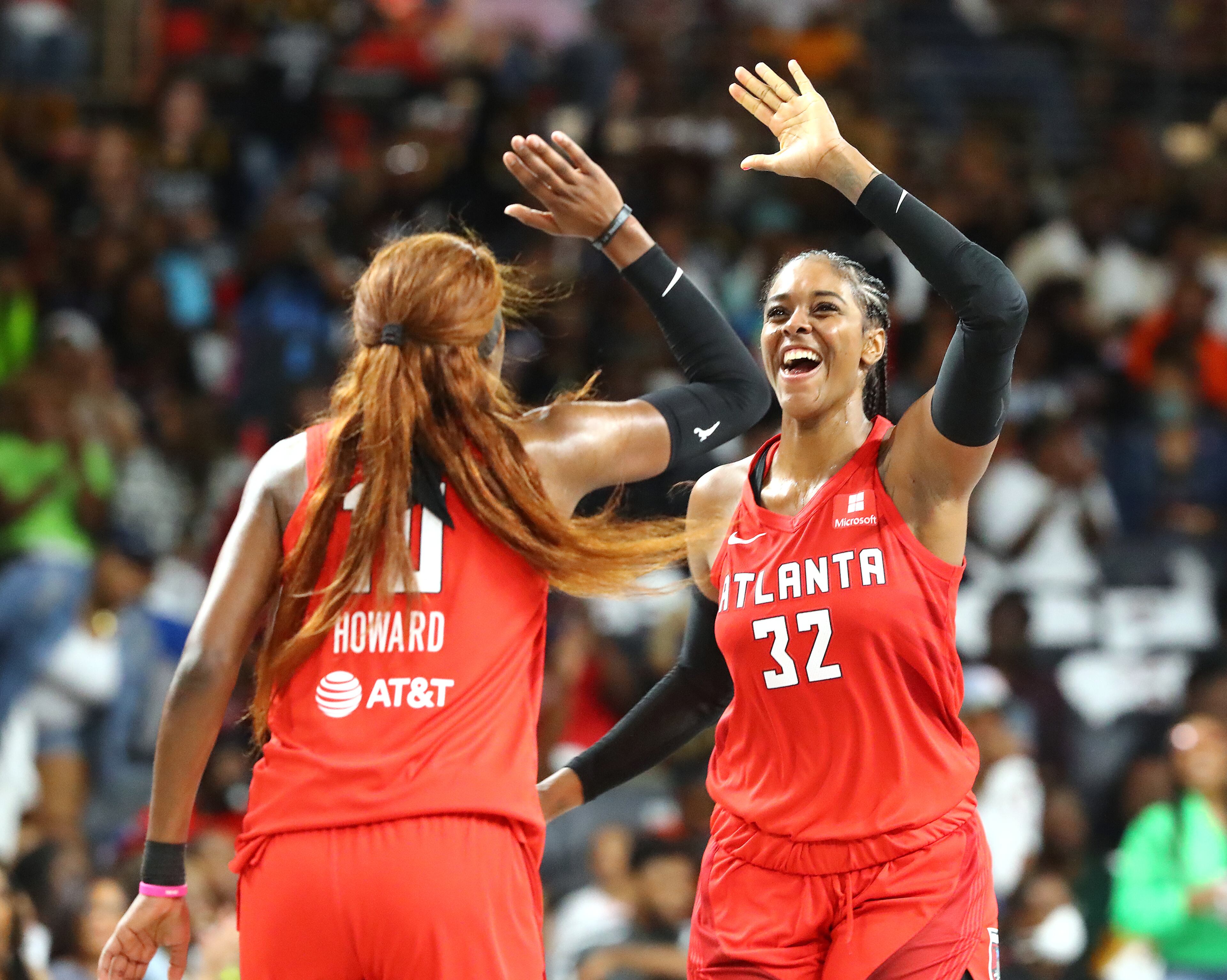 Atlanta Dream guard Rhyne Howard (left) gets five from forward Cheyenne Parker after hitting a three-pointer during a 77-75 victory over the Los Angeles Sparks during their home opener in a WNBA basketball game on Wednesday, May 11, 2022, in College Park. “Curtis Compton / Curtis.Compton@ajc.com”