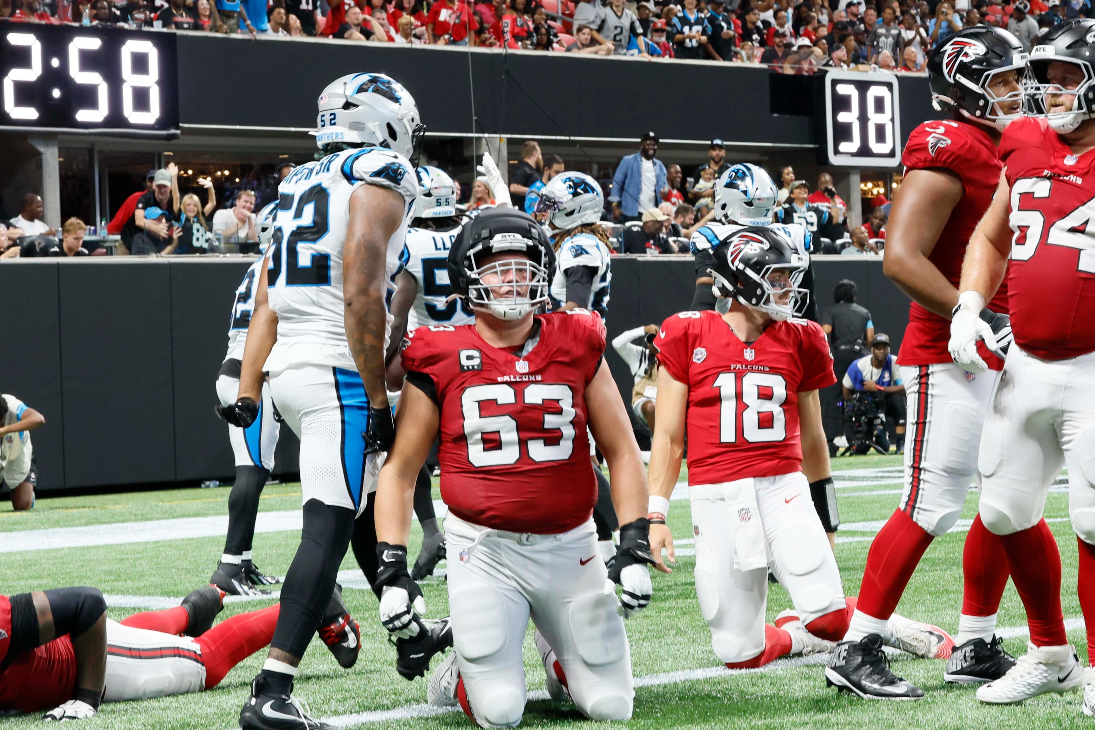 Atlanta Falcons guard Chris Lindstrom (63)and Atlanta Falcons quarterback Jack Strand (18) kneel down as Carolina Panthers celebrate a touchdown after a fumble recovery during the second half of an NFL football game at Mercedes-Benz Stadium in Atlanta on Sunday, Sept. 20, 2026. (Miguel Martinez/AJC)