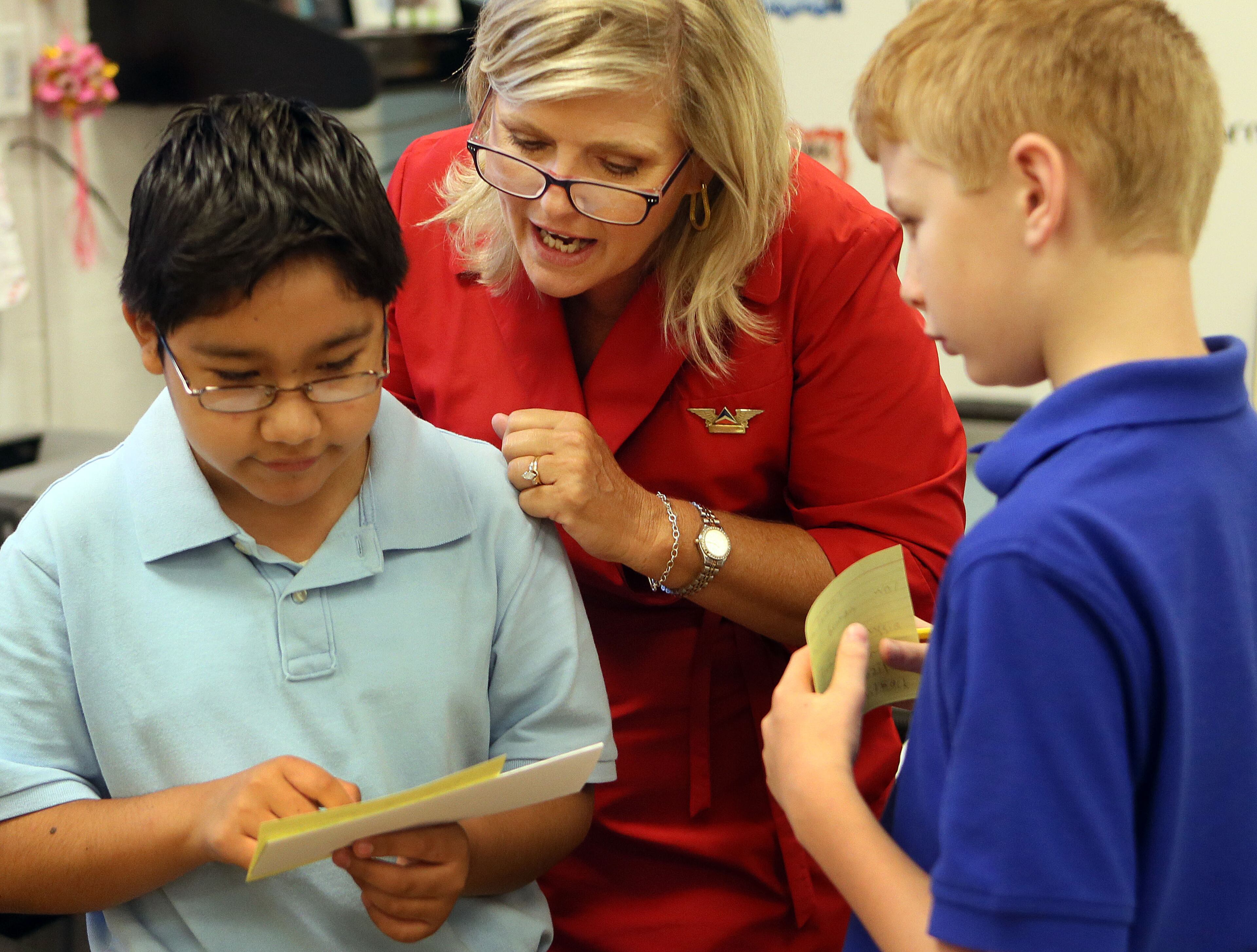 Campbell Middle School sixth grade teacher Rhonda Lokey (center) helped Jose H. (left) & Davis P. work together as she treated her new Humanities students to an experience similar to boarding an international flight on their first day of class in Smyrna on Wednesday.