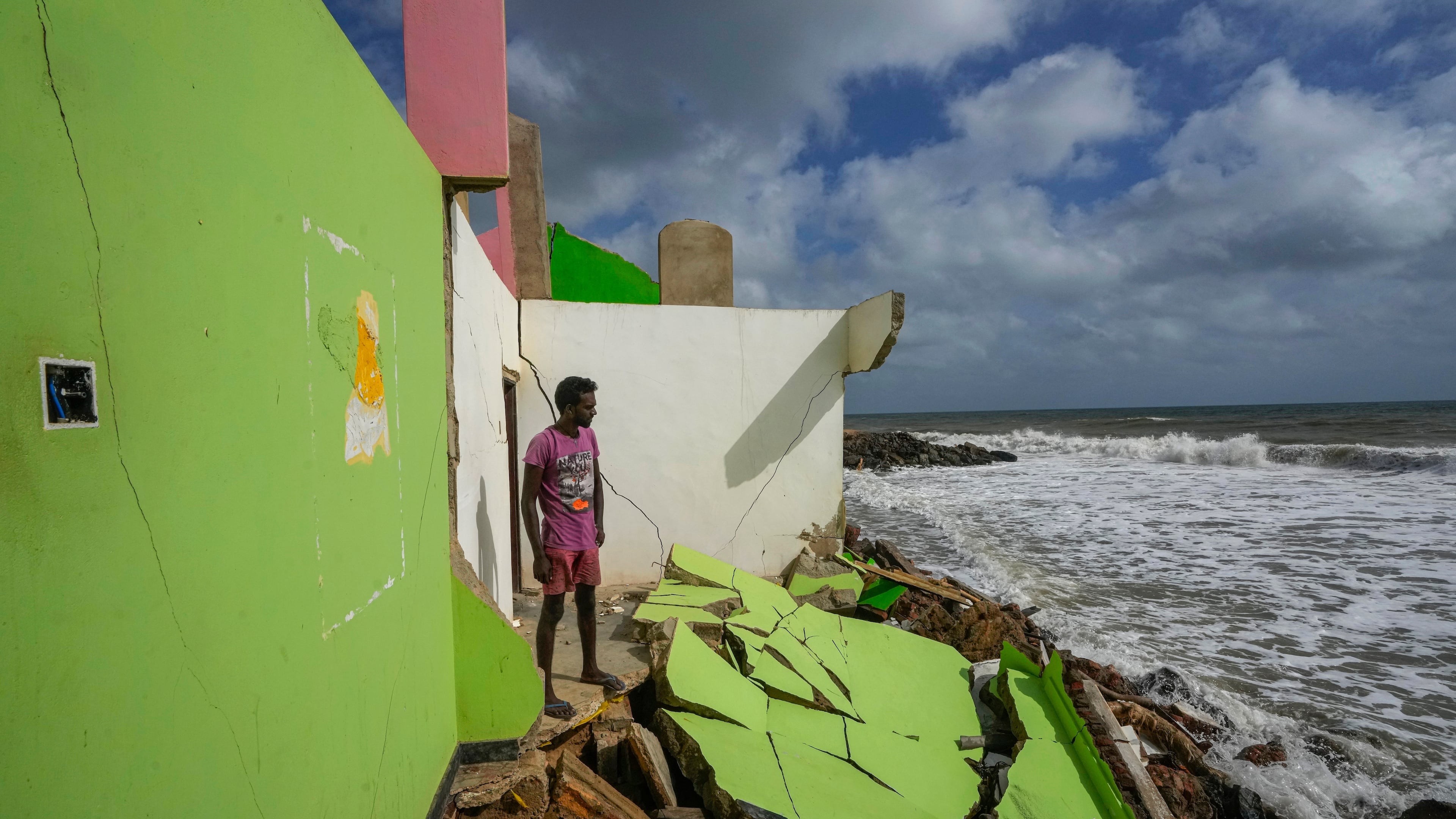 FILE - Dilrukshan Kumara looks at the ocean as he stands by the remains of his family's home in Iranawila, Sri Lanka, June 15, 2023. (AP Photo/Eranga Jayawardena, File)