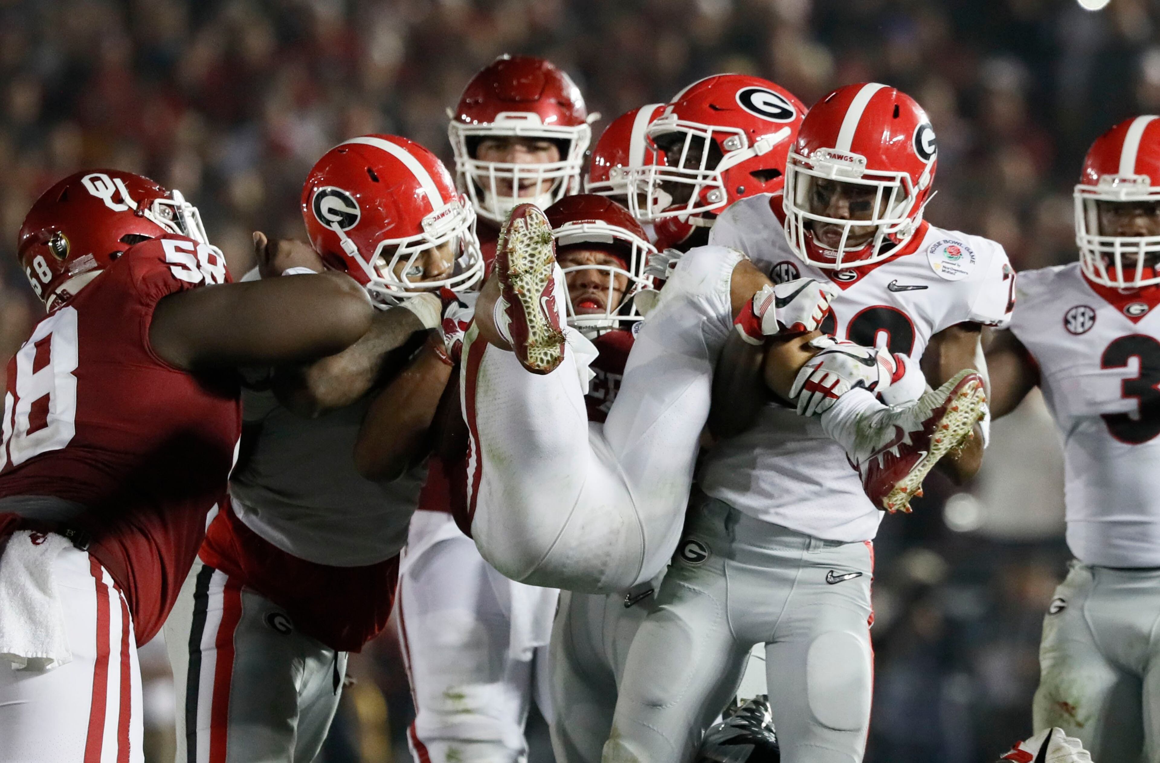 1/1/18 - Pasadena - Georgia defenders put the stop on Oklahoma Sooners running back Rodney Anderson (24) during the second half of the College Football Playoff Semifinal at the Rose Bowl Game on Monday, January 1, 2018, in Pasadena. BOB ANDRES /BANDRES@AJC.COM