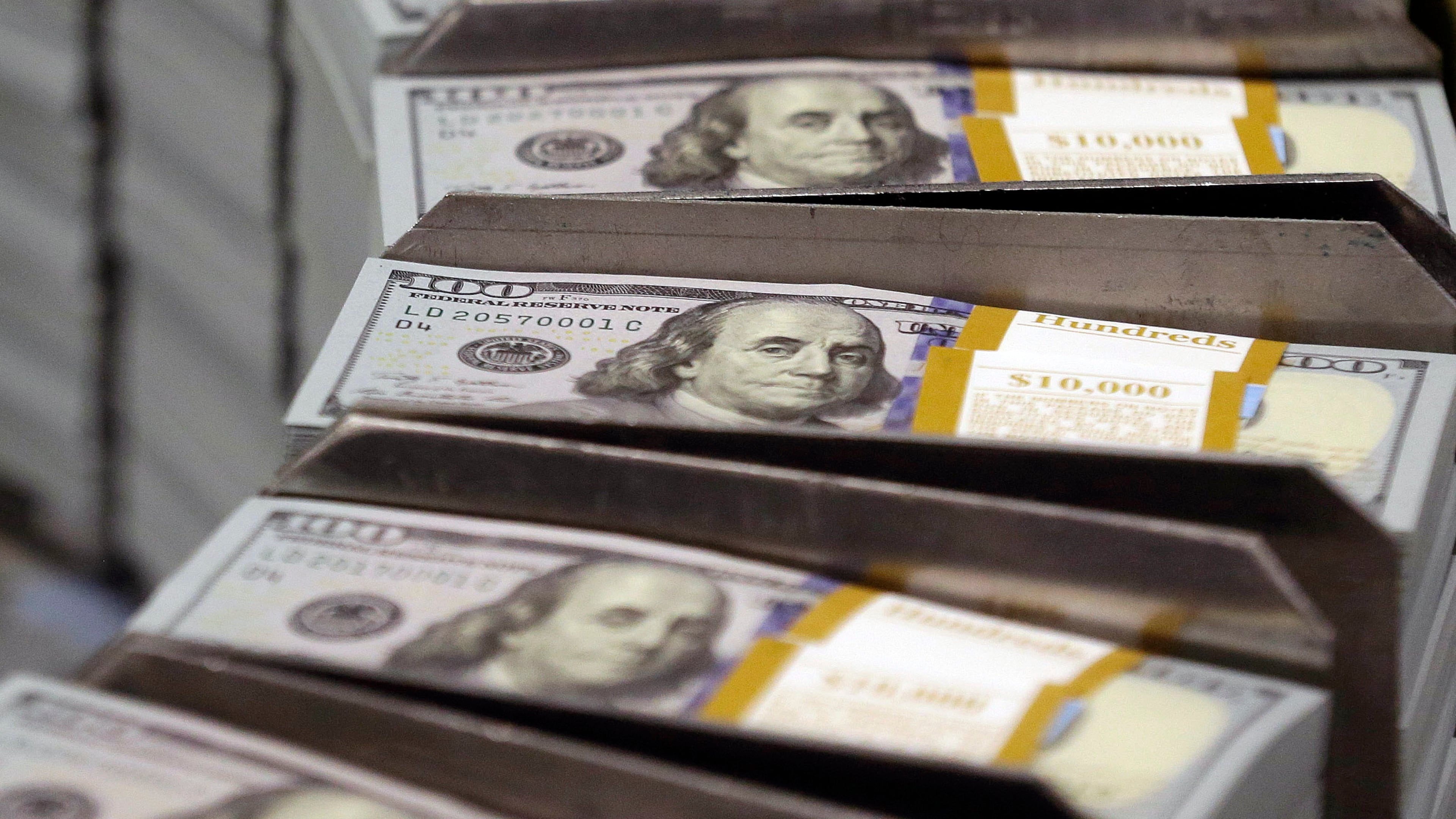 Freshly cut stacks of $100 bills make their way down the line at the Bureau of Engraving and Printing Western Currency Facility in Fort Worth, Texas. More Georgians are defaulting on their student loans, according to new reporting by the Associated Press. (AP FILE)