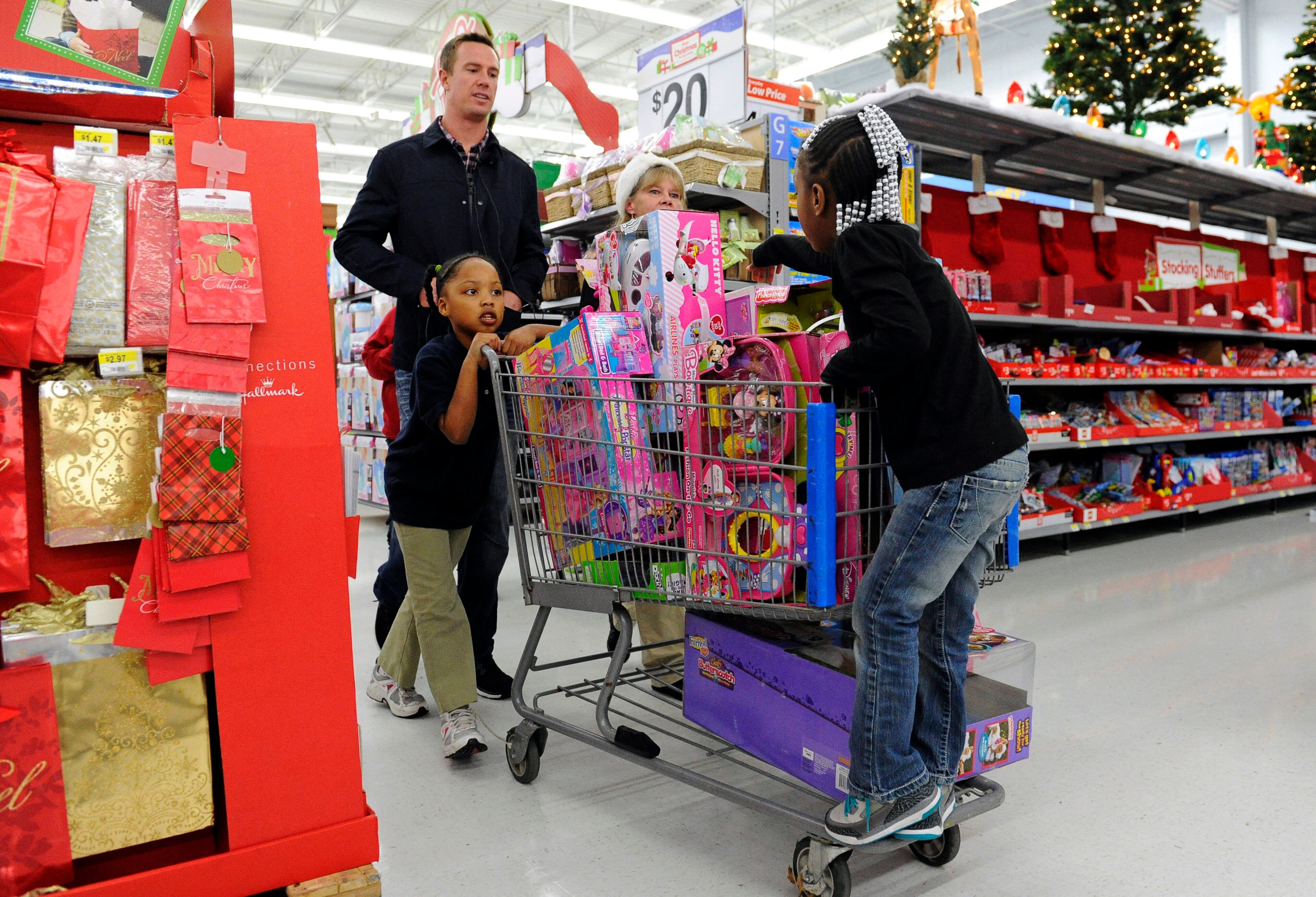 Atlanta Falcons quarterback Matt Ryan helps children push a cart of toys while he and teammates participated in the "Shop with a Jock" program, which provides a $100 gift card and a shopping experience to children from an Atlanta-area mission at a Walmart department store, Tuesday, Dec. 11, 2012, in Suwanee.