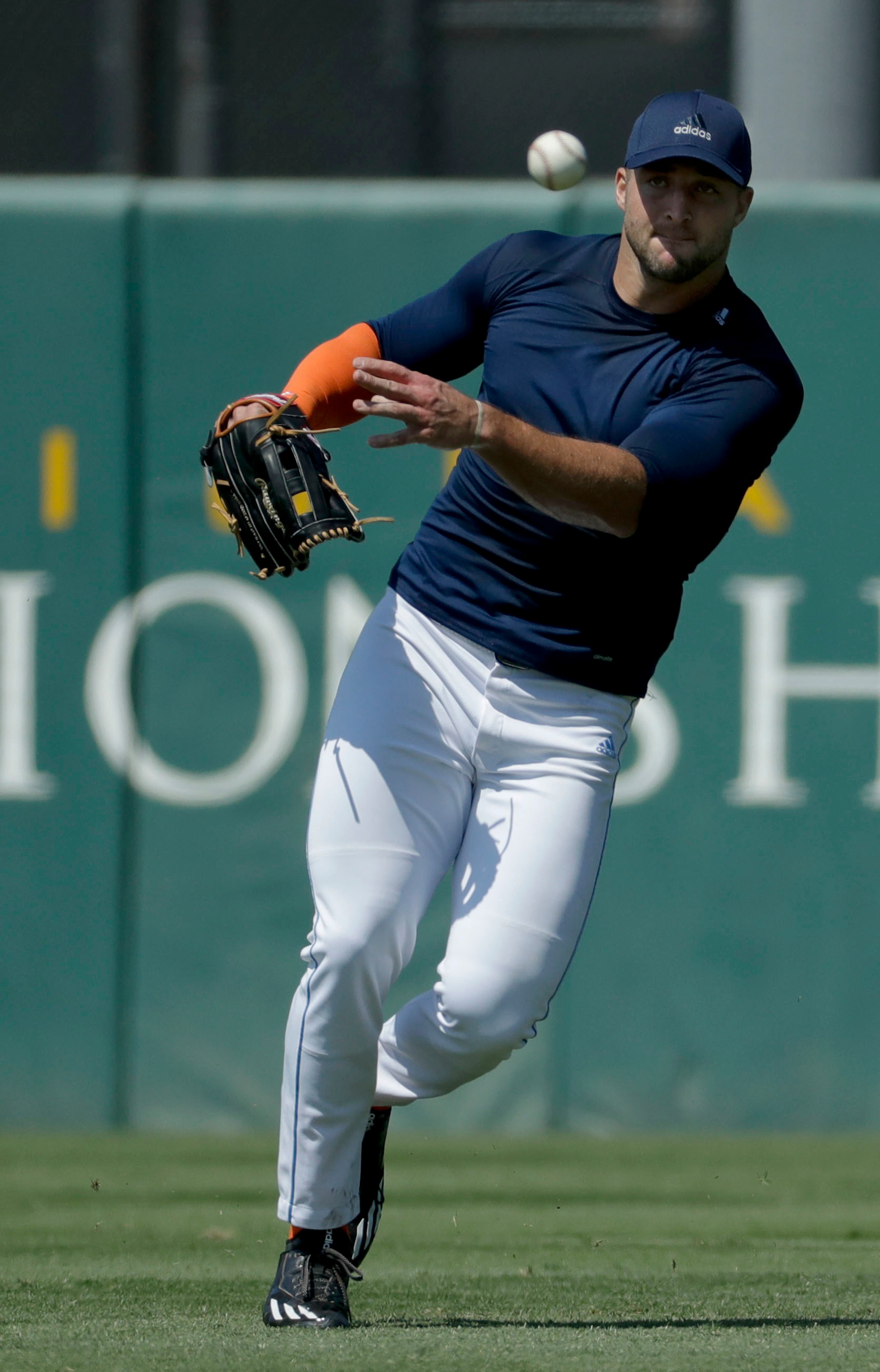 Former NFL quarterback, Tim Tebow fields a fly ball for baseball scouts and the media during a showcase on the campus of the University of Southern California, Tuesday, Aug. 30, 2016 in Los Angeles. The Heisman Trophy winner works out for a big gathering of scouts on USC's campus in an attempt to start a career in a sport he hasn't played regularly since high school. (AP Photo/Chris Carlson)