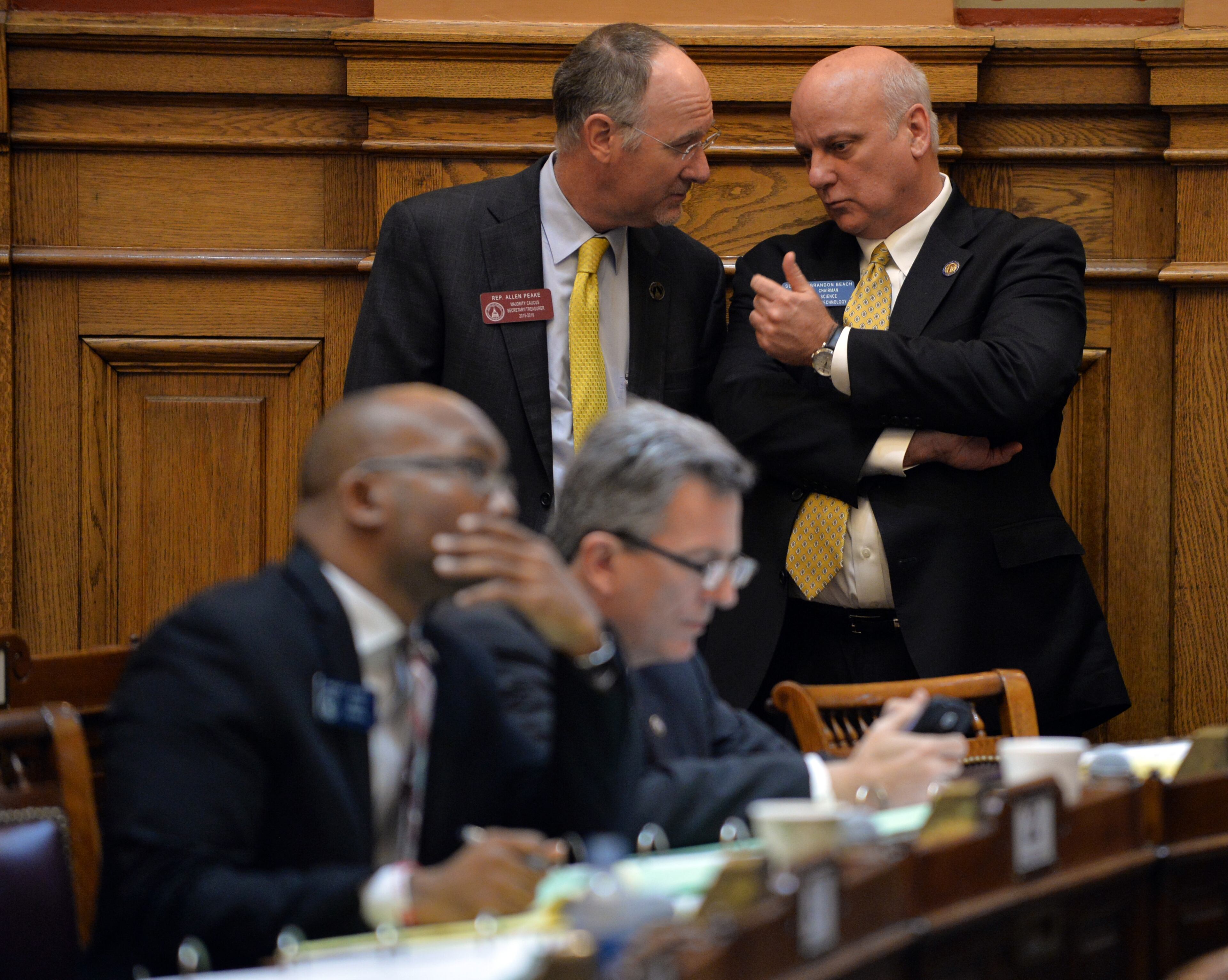 March 13, 2015 Atlanta: Rep. Allen Peake-R chats with Sen. Brandon Beach-R as Sen. Lindsey Tippins-R, not pictured, introduces the Senate version of a medical marijuana bill, SB 185, Friday March 13, 2015. The bill is one of two medical marijuana bills that are being considered this session. SB 185 is a much more limiting bill than HB 1 introduced by Rep. Peake earlier in the session. Crossover Day, the 30th day of the 40-day legislative session, is when most bills must pass the chamber they originated in to be considered in the other chamber. So a bill that was introduced in the House must receive a favorable vote today for it to be considered in the Senate this session. Likewise, a bill that was introduced in the Senate must receive a favorable vote today to be considered by the House.. There are other ways a bill can make it into law after the deadline, but it is a very difficult process. BRANT SANDERLIN / BSANDERLIN@AJC.COM