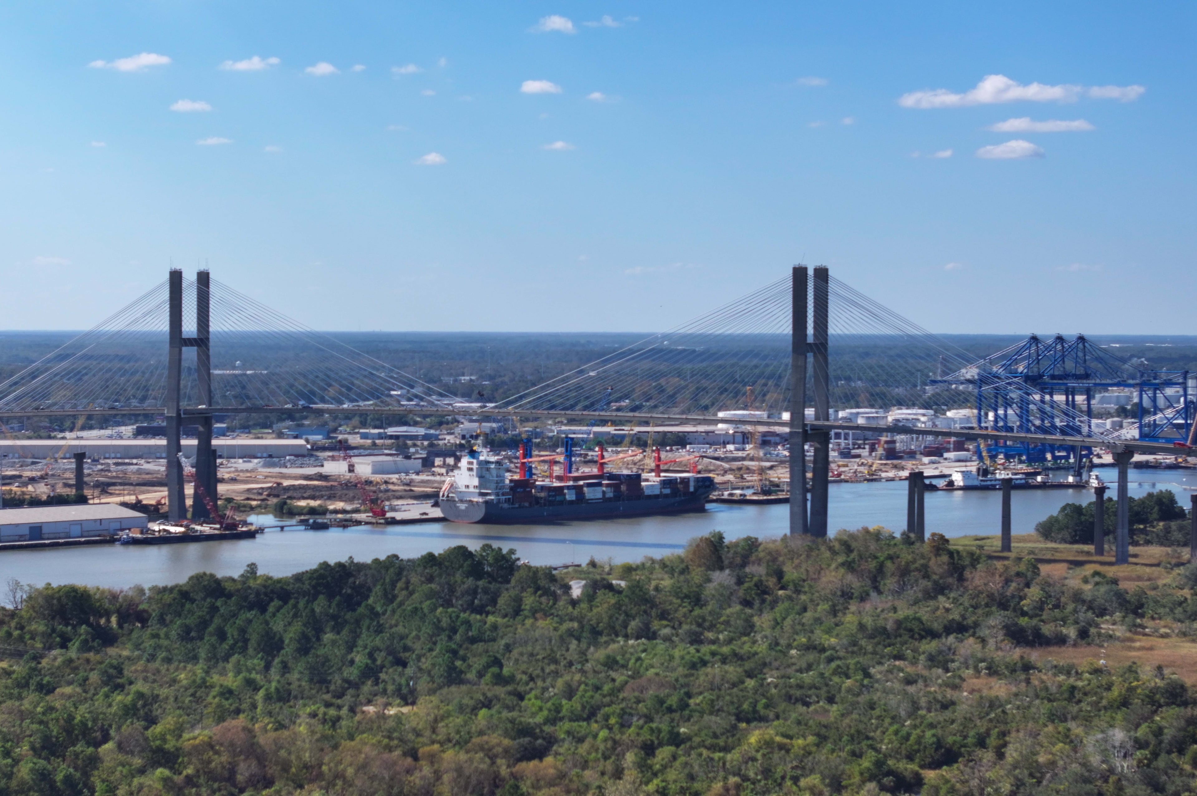 An aerial image of the Talmadge Bridge above the Savannah River with the Georgia Ports Authority Ocean Terminal in the background. (Miguel Martinez/AJC)