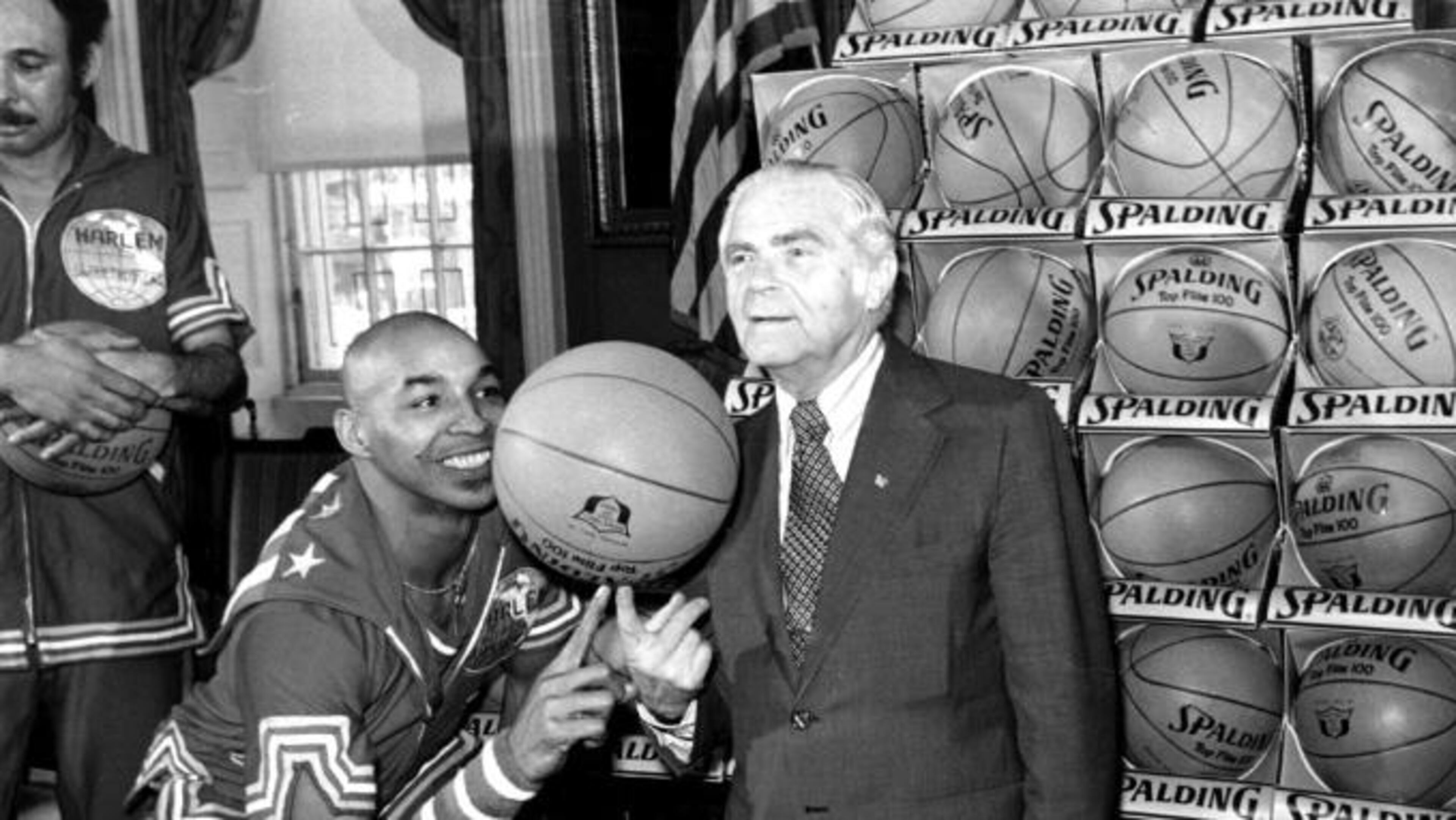 Fred “Curly” Neal shows New York City Mayor Abe Beame the art of balancing a basketball on a finger during a ceremony at City Hall.