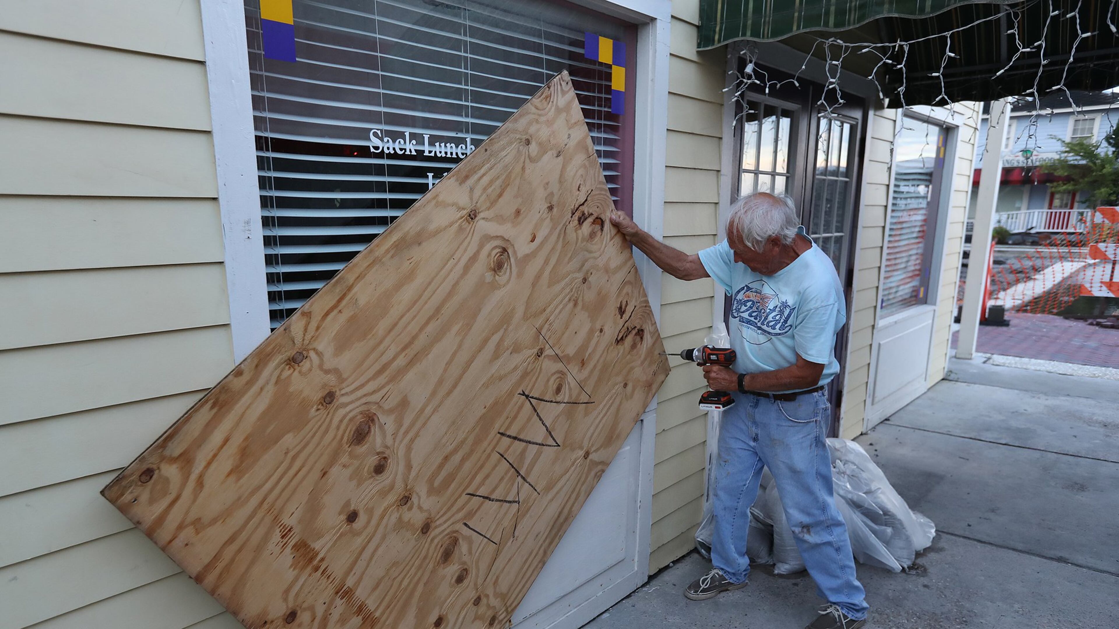 Local resident and business owner Jimmy Mock returns to his St. Marys general store on Thursday, Sept. 5, 2019, taking the boards down to begin moving merchandise back in and reopening the business after Hurricane Dorian. Mock’s business appeared to have escaped with minor wind damage. CURTIS COMPTON / CCOMPTON@AJC.COM