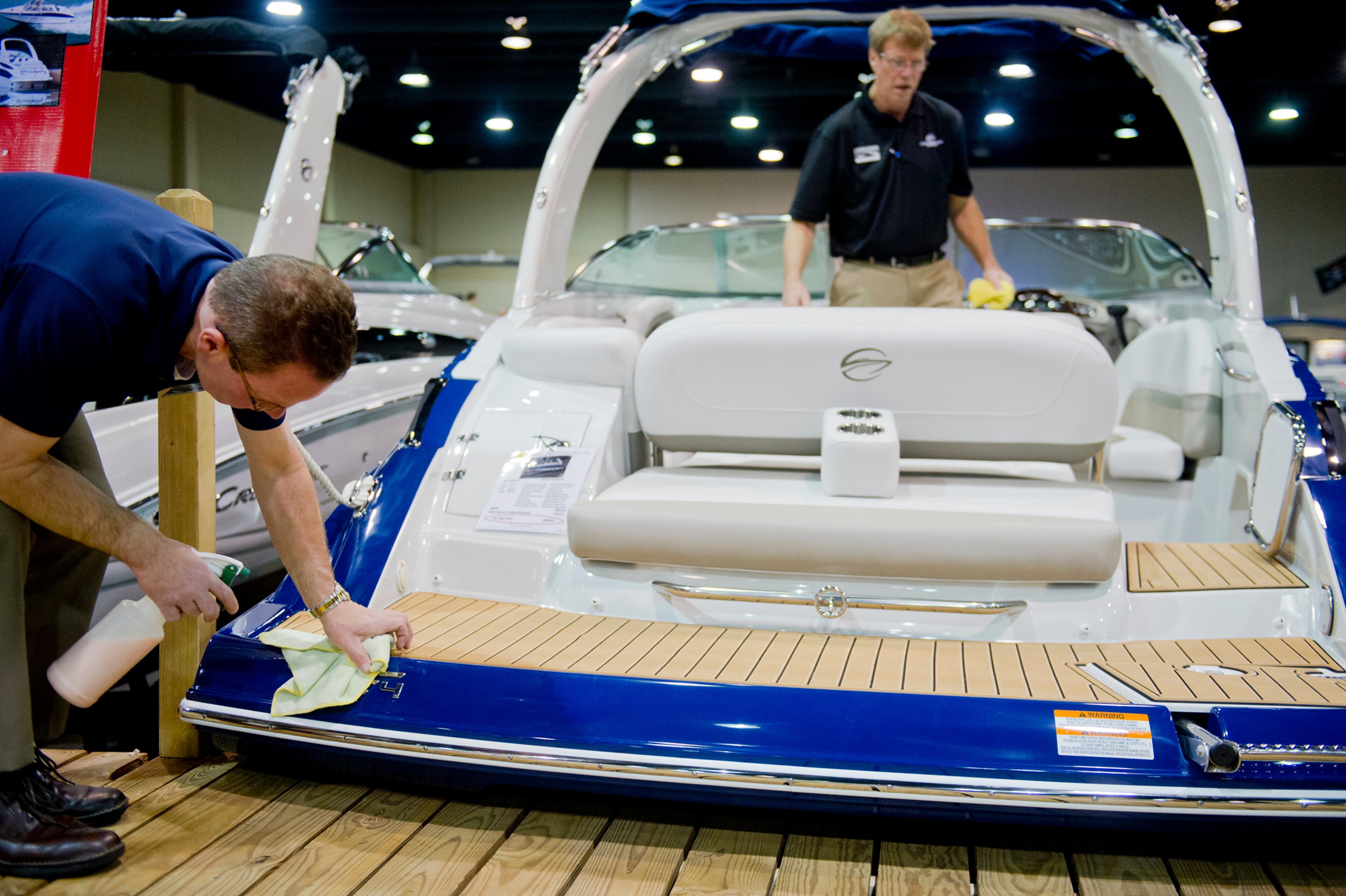 Eddie Marszalek (left) and Paul Williams clean one of the boats on display during the Spring Into Summer Boat Show at the Gwinnett Center in Duluth on Sunday, March 9, 2014. The three-day boat show had 30 vendors. JONATHAN PHILLIPS / SPECIAL