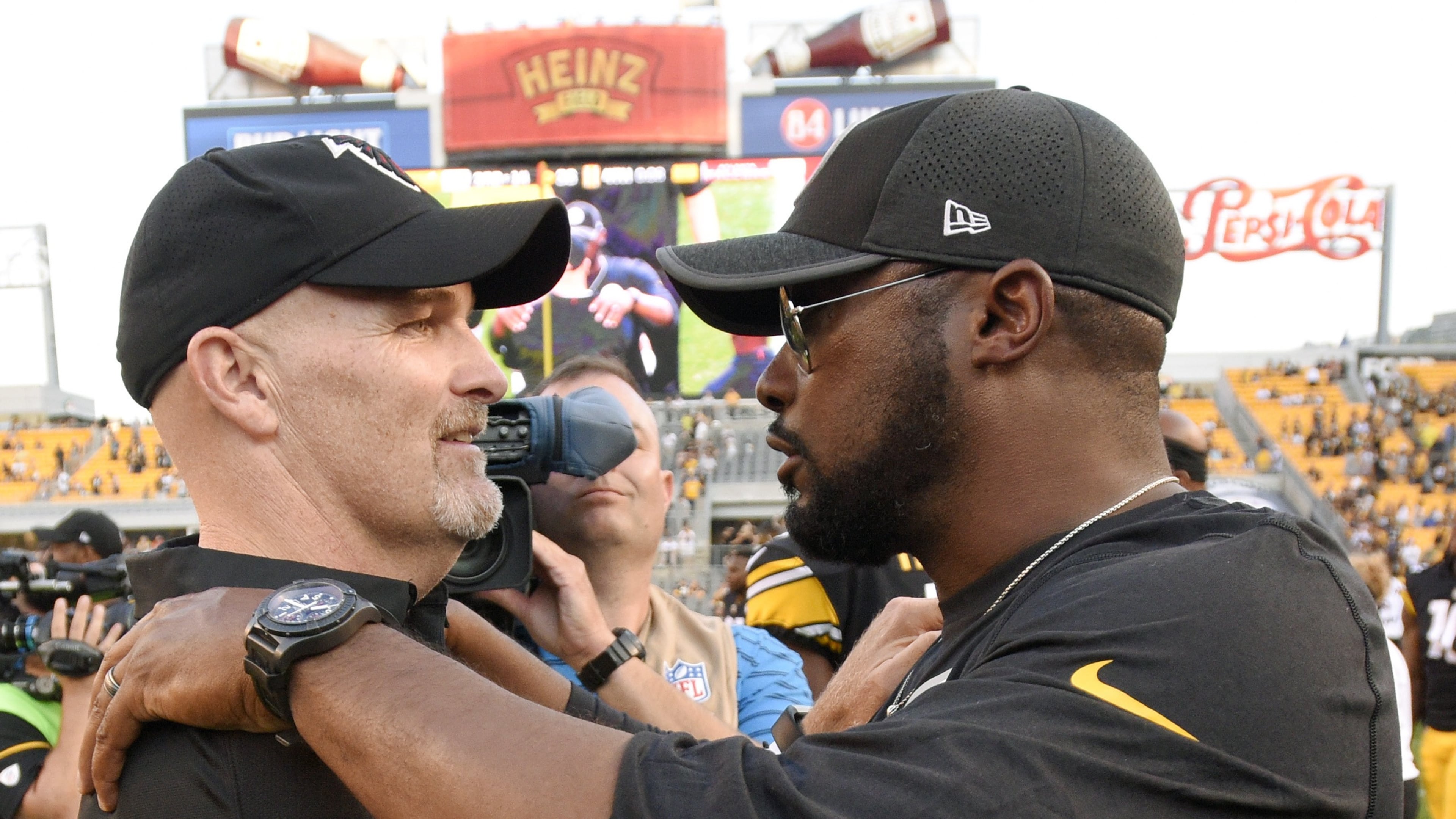 Atlanta Falcons head coach Dan Quinn, left, and Pittsburgh Steelers head coach Mike Tomlin embrace after an NFL preseason football game, Sunday, Aug. 20, 2017, in Pittsburgh. The Steelers won 17-13. (AP Photo/Don Wright)