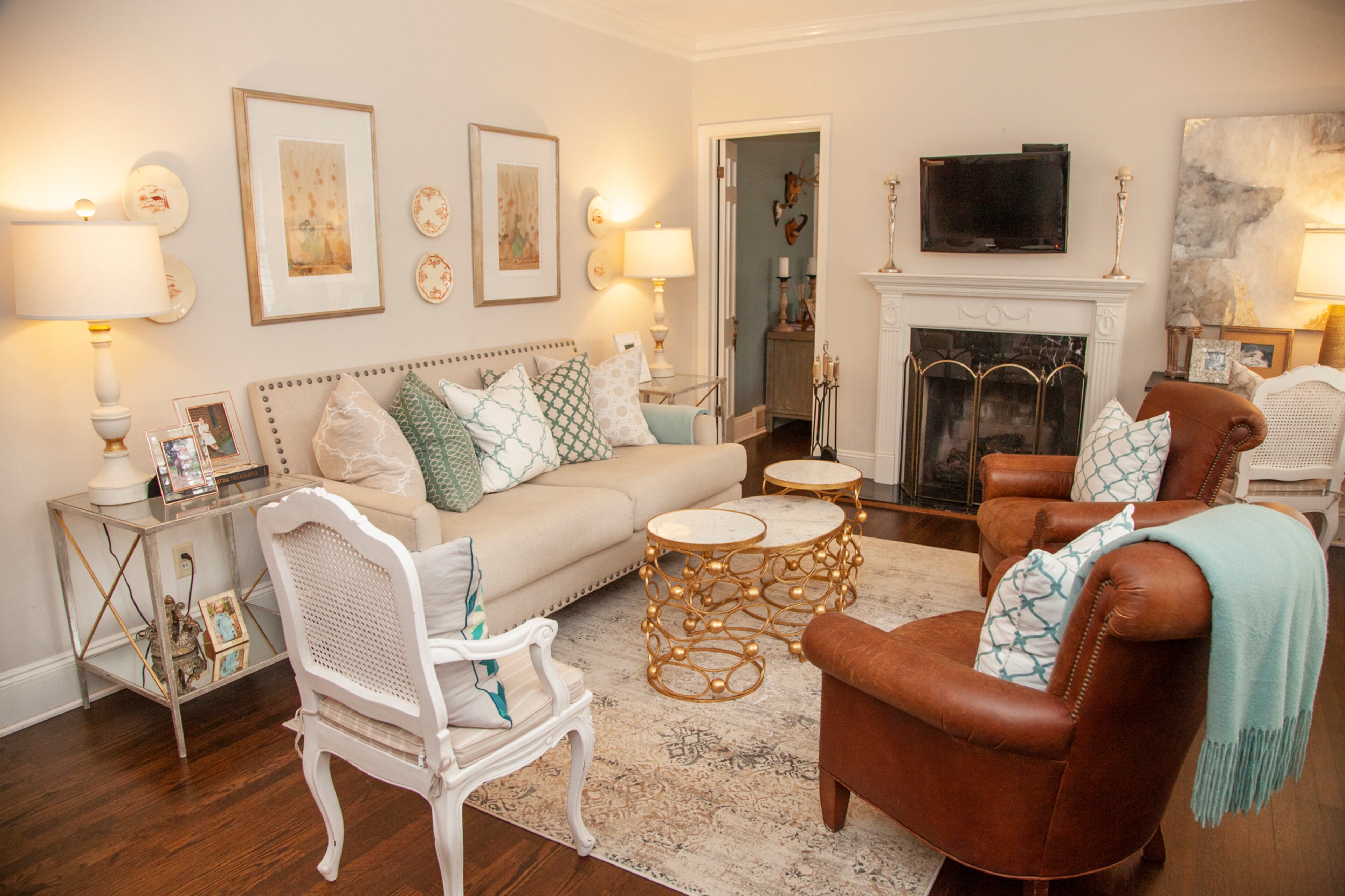 The interiors have a French country flair with metallic accents. The coffee table is from Ro Sham Beaux and the leather armchairs are from Vanguard Furniture.