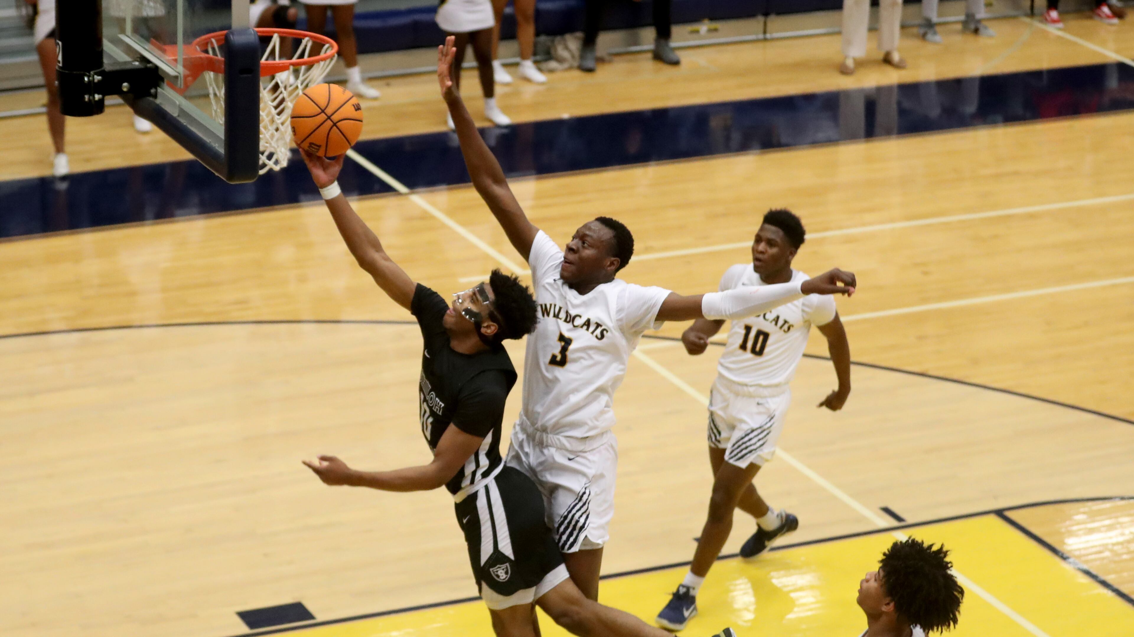 Shiloh guard Caleb Golden (10) attempts a layup against Wheeler forward Ja'Hiem Hudson (3) in the first half of Thursday's game. (Jason Getz/Special to the AJC)