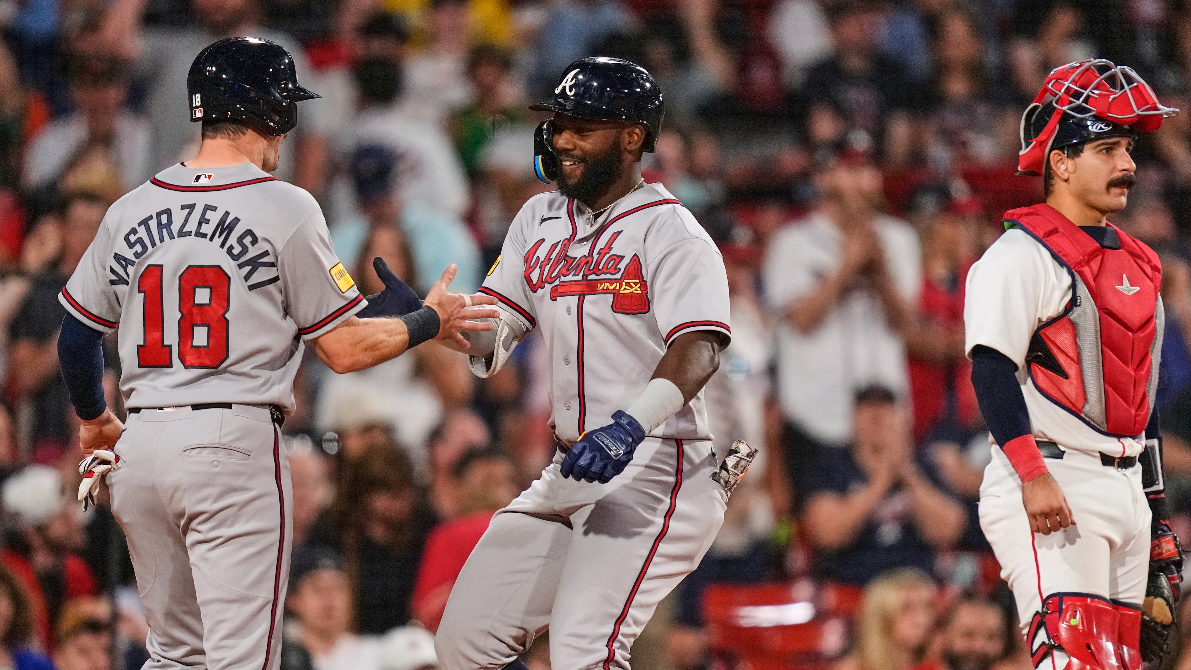 Atlanta Braves' Michael Harris II, center, is congratulated by Mike Yastrzemski (18) after his two-run home run, as Boston Red Sox's Mickey Gasper (30) waits for play to resume, during the eighth inning of a baseball game, Tuesday, May 26, 2026, in Boston. (AP Photo/Charles Krupa)