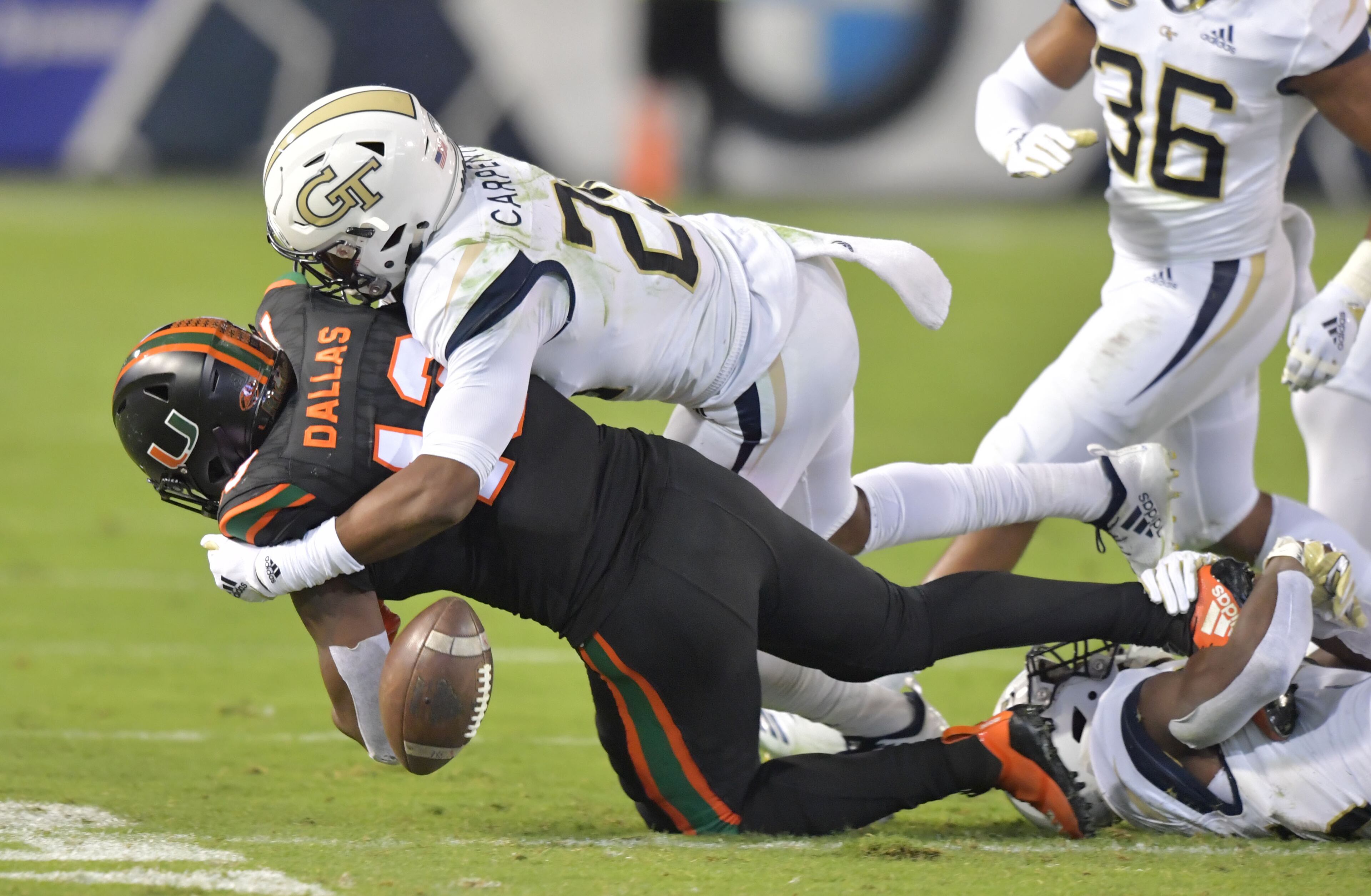 November 10, 2018 Atlanta - Miami running back DeeJay Dallas (13) gets tackled by Georgia Tech defensive back Tariq Carpenter (29) and Georgia Tech defensive back Charlie Thomas (45) causing a fumble later being picked up by Georgia Tech defensive back Ajani Kerr (38) in the first half at Bobby Dodd Stadium on Saturday, November 10, 2018. HYOSUB SHIN / HSHIN@AJC.COM