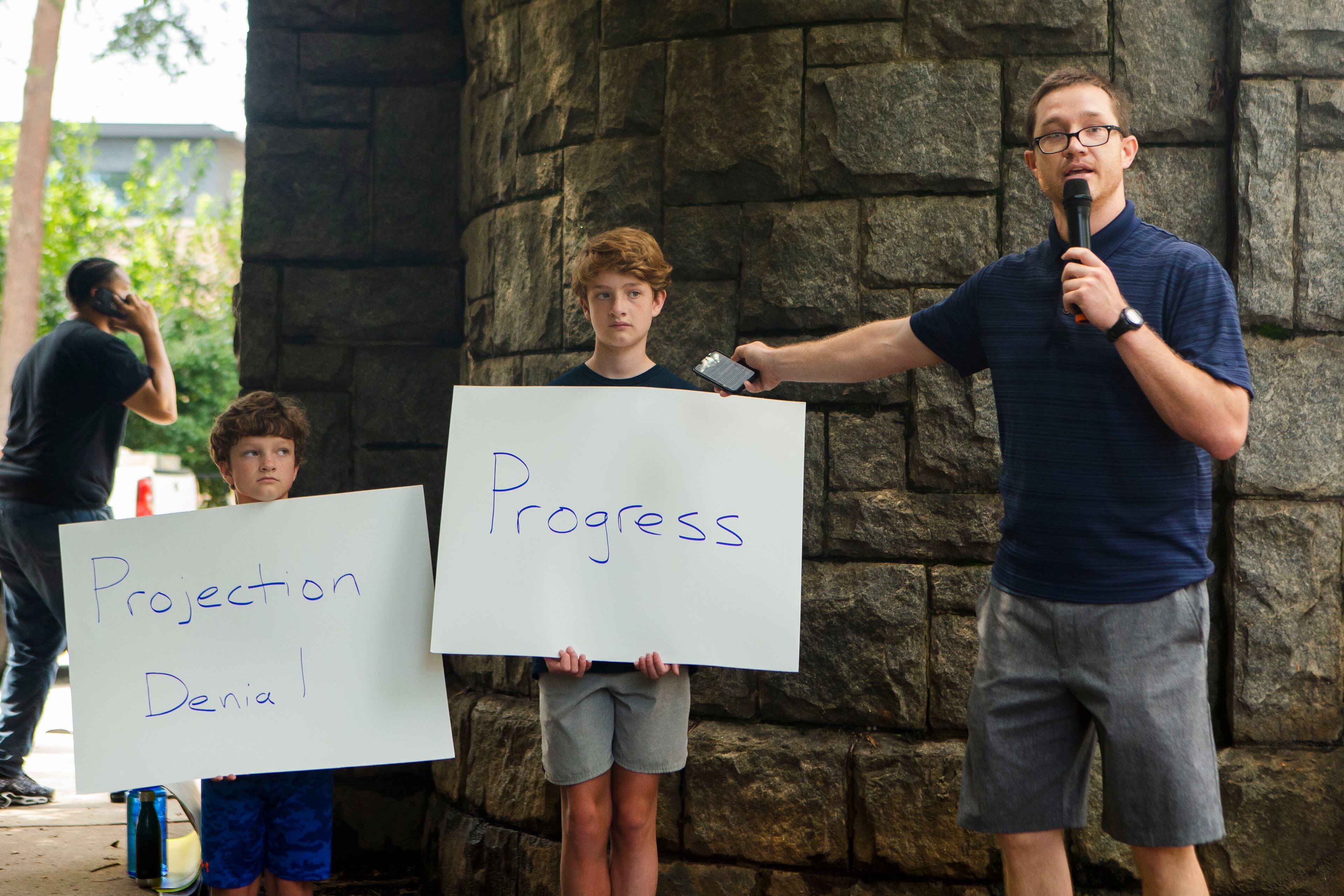 Charlie Copp (right), an educator in Atlanta Public Schools, speaks during a back-to-school rally for Georgia educators accompanied by his sons Charles Baxter Copp (left) and James Bennett Copp (center) on Saturday, July 23, 2022, at Piedmont Park in Atlanta. Teachers, community members and students gathered to speak against new state laws that limit classroom discussions about race and streamline the process for banning books in schools. (Christina Matacotta for The Atlanta Journal-Constitution)