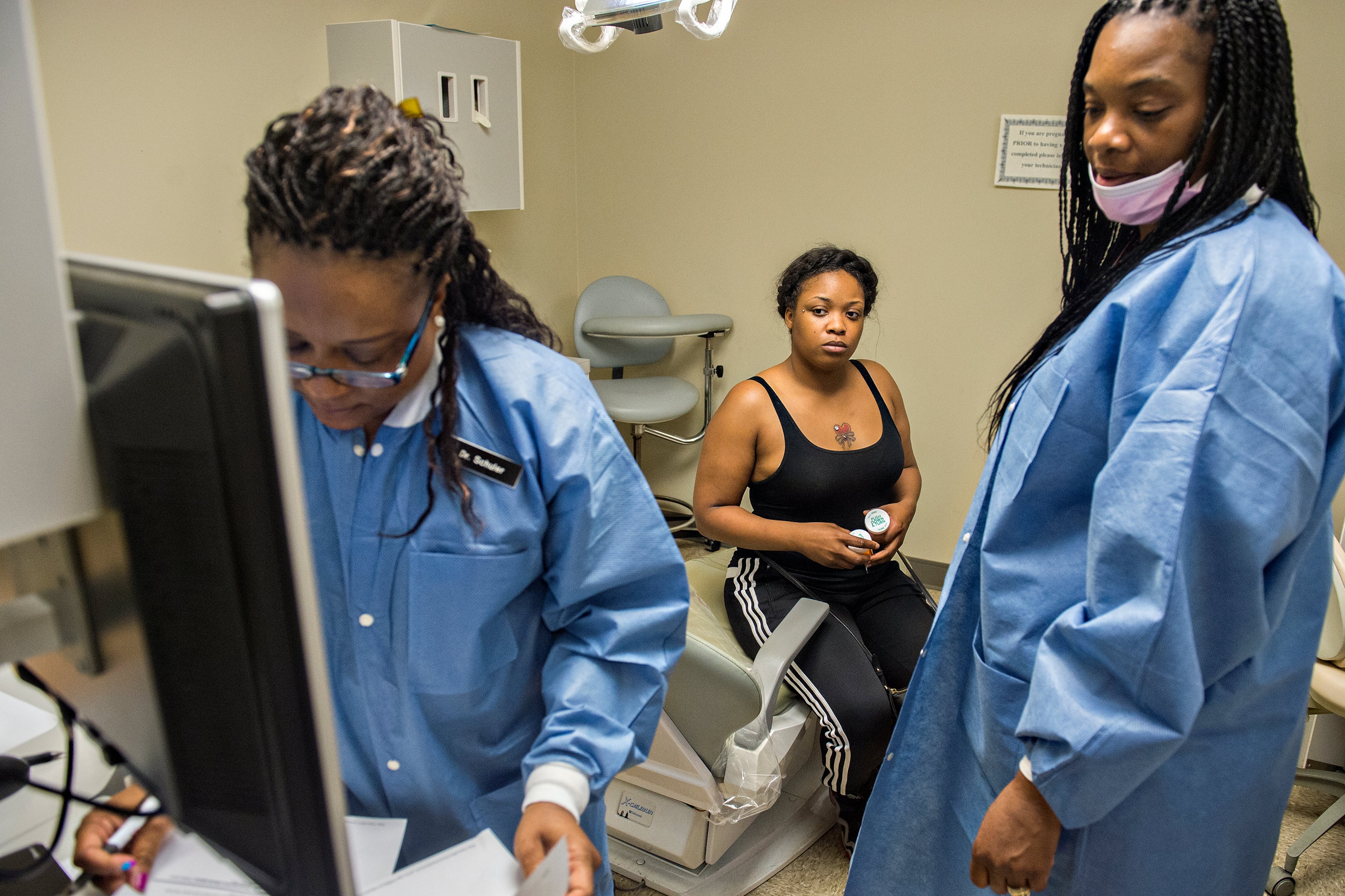 Deenay Vestal (center) waits for final instructions from Dr. Katrina Schuler-Bacon (left) and Vickie Francis during a visit to Mercy Care's dental clinic off Decatur Street in Atlanta on Tuesday, May 19. Vestal received two prescriptions for a wisdom tooth that is cutting through her gums. While dental disease seldom kills, it does lead to tooth loss and infections. It also can affect how a person eats, drinks and interacts with society. Problems with the tongue and gums can also be indications of cancer, and dentists can often detect problems early, before these cancers become advanced. JONATHAN PHILLIPS / SPECIAL