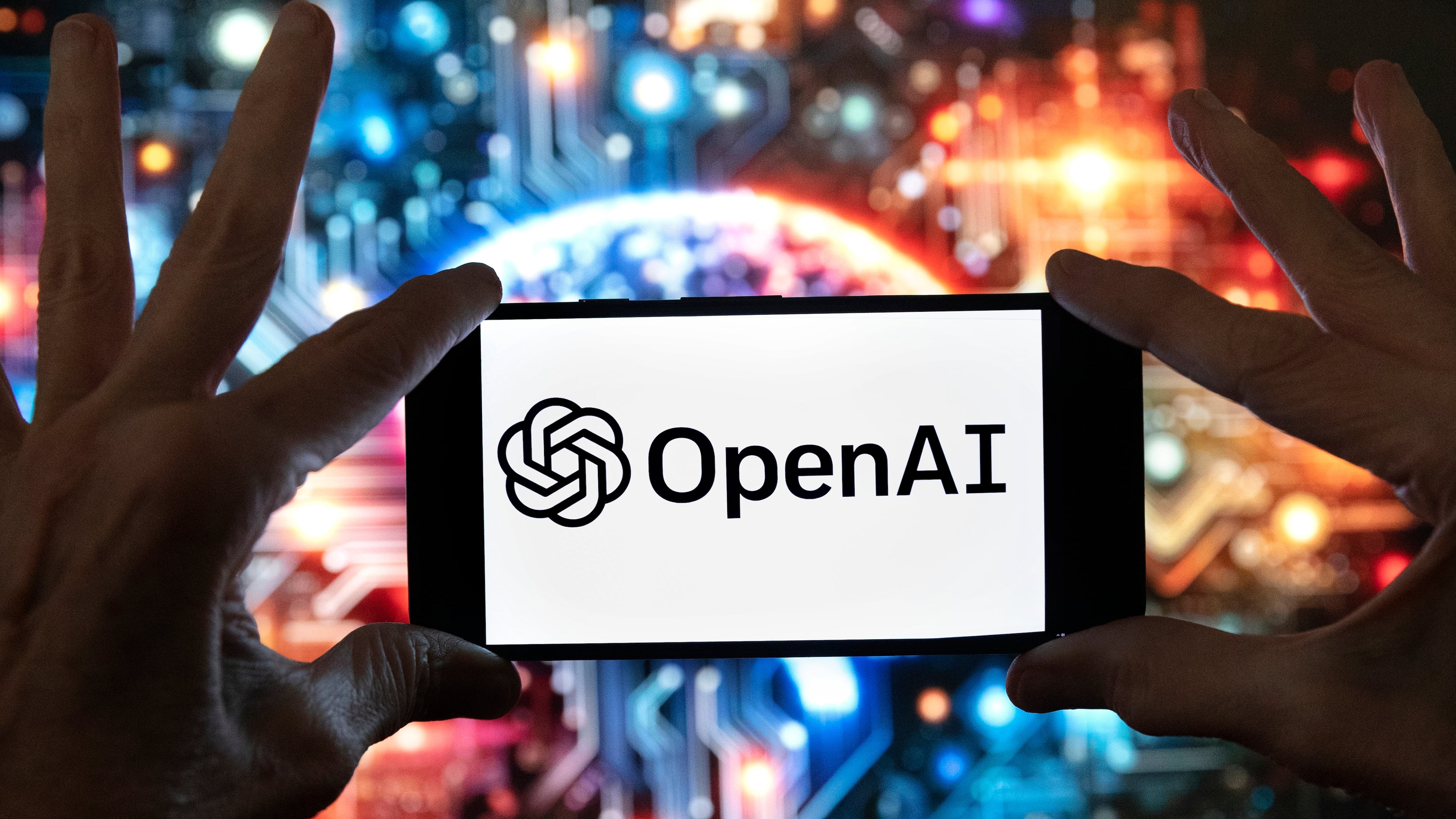 FILE - The OpenAI logo is displayed on a cell phone in front of an image generated by ChatGPT's Dall-E text-to-image model, Dec. 8, 2023, in Boston. (AP Photo/Michael Dwyer, File)