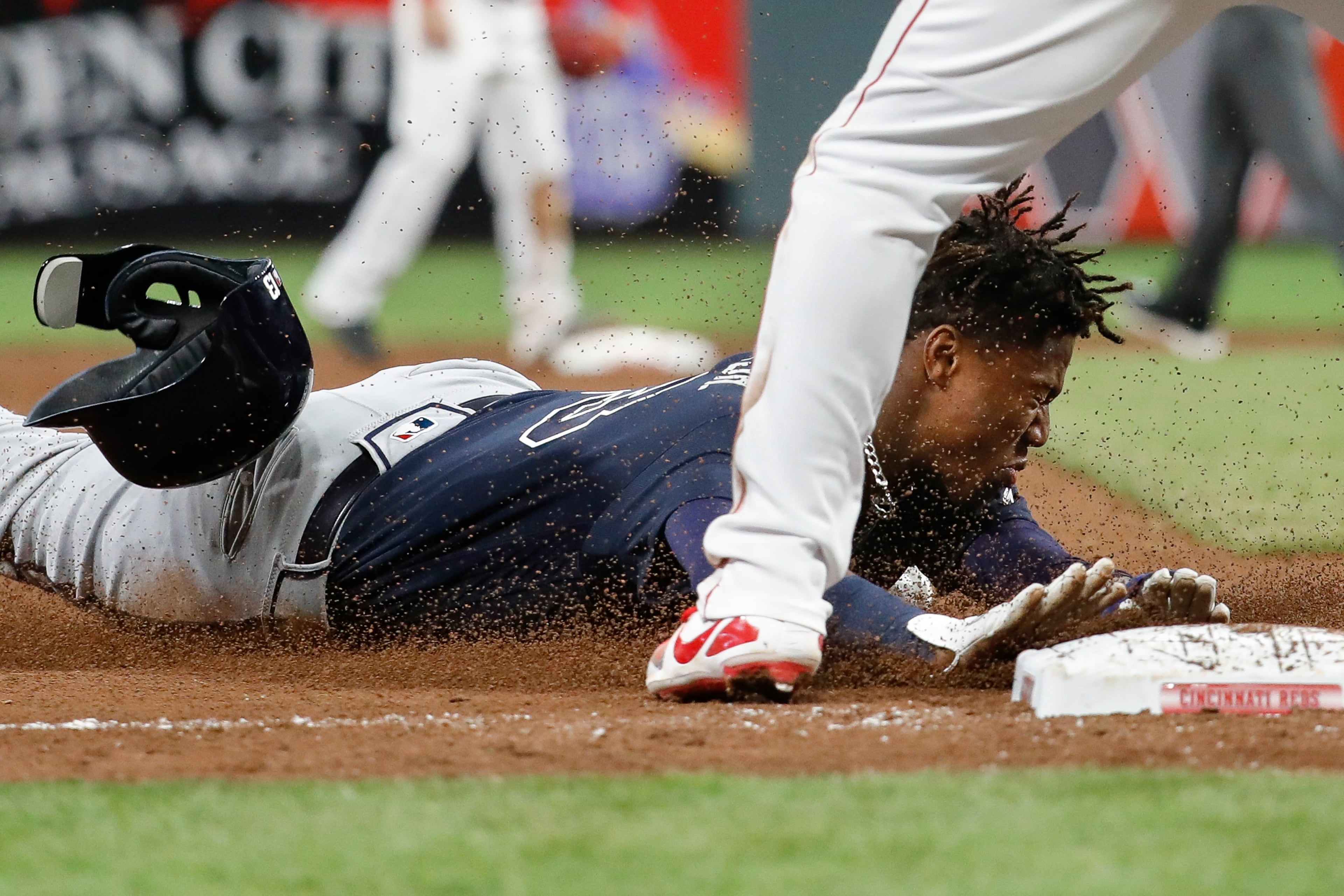 Atlanta Braves' Ronald Acuna Jr. advances to third against Cincinnati Reds third baseman Cliff Pennington on a single by Dansby Swanson during the eighth inning of a baseball game, Wednesday, April 25, 2018, in Cincinnati. (AP Photo/John Minchillo)