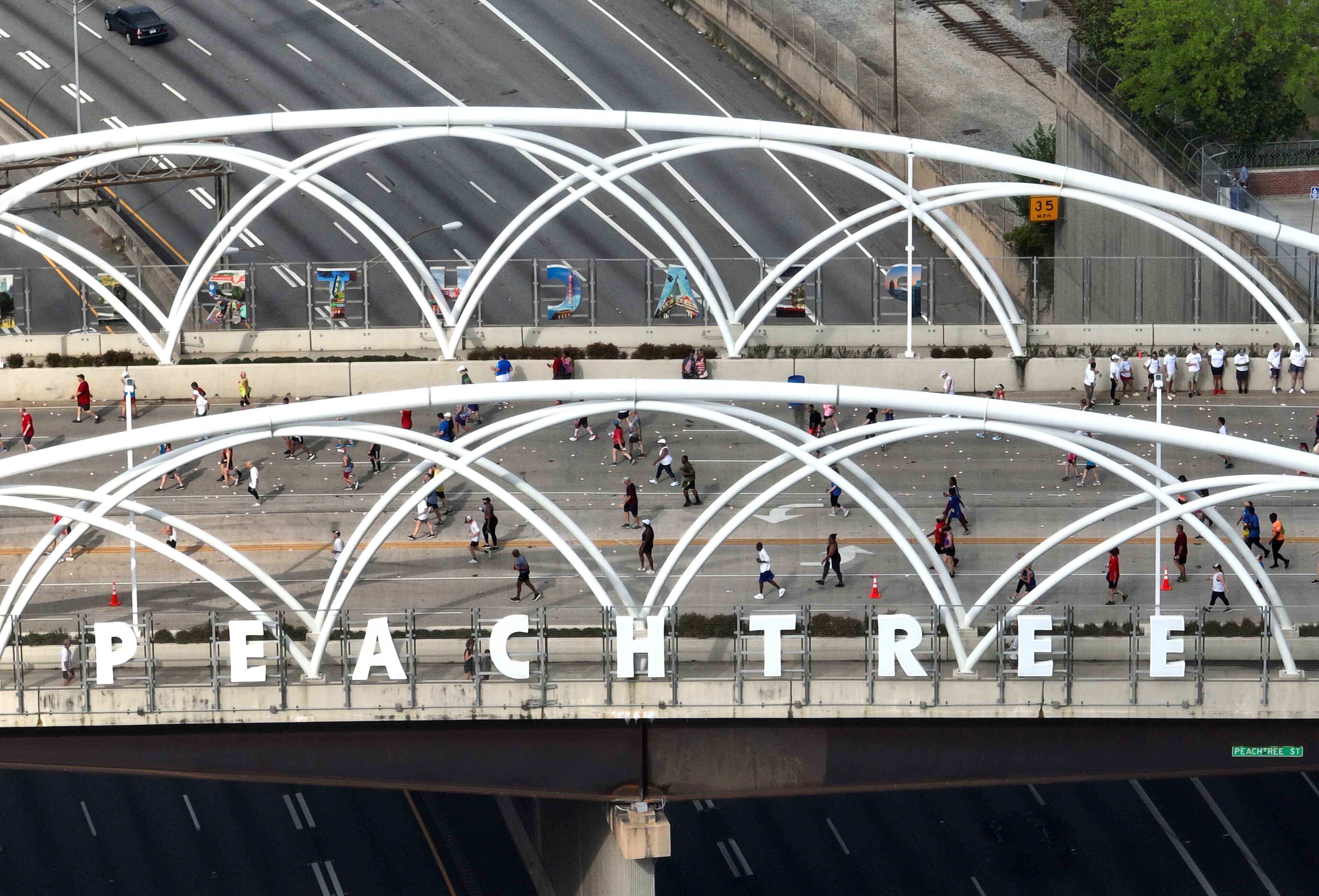Aerial view shows runners on Peachtree Street North Bridge during the 53rd Atlanta Journal-Constitution Peachtree Road Race in Atlanta on Monday, July 4, 2022. (Hyosub Shin / Hyosub.Shin@ajc.com)
