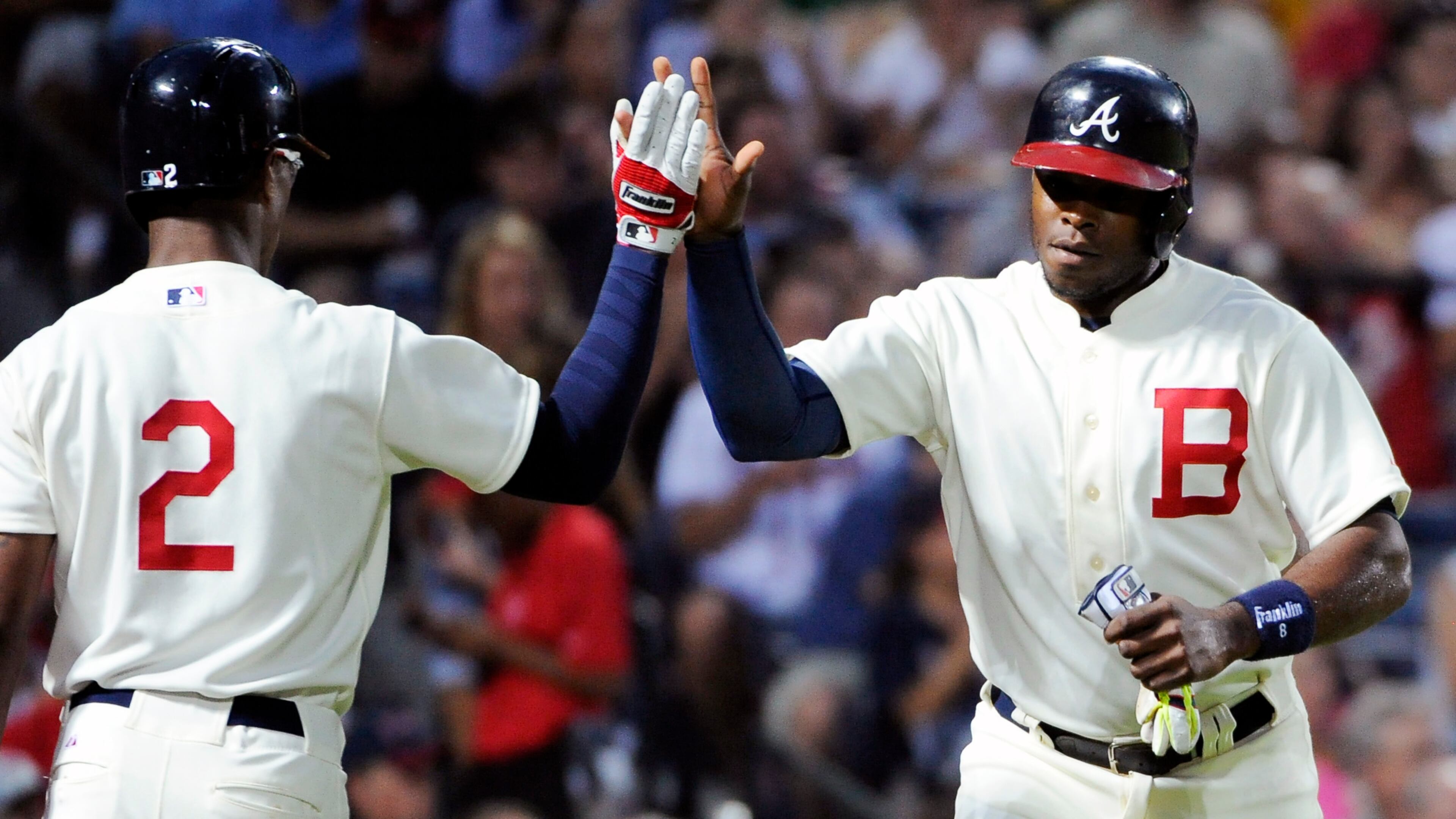 Atlanta Braves' Justin Upton, right, is congratulated by his brother B.J. Upton after he scores on an Andrelton Simmons single against the Oakland Athletics during the fourth inning of a baseball game Saturday, Aug. 16, 2014, in Atlanta. (AP Photo/David Tulis)