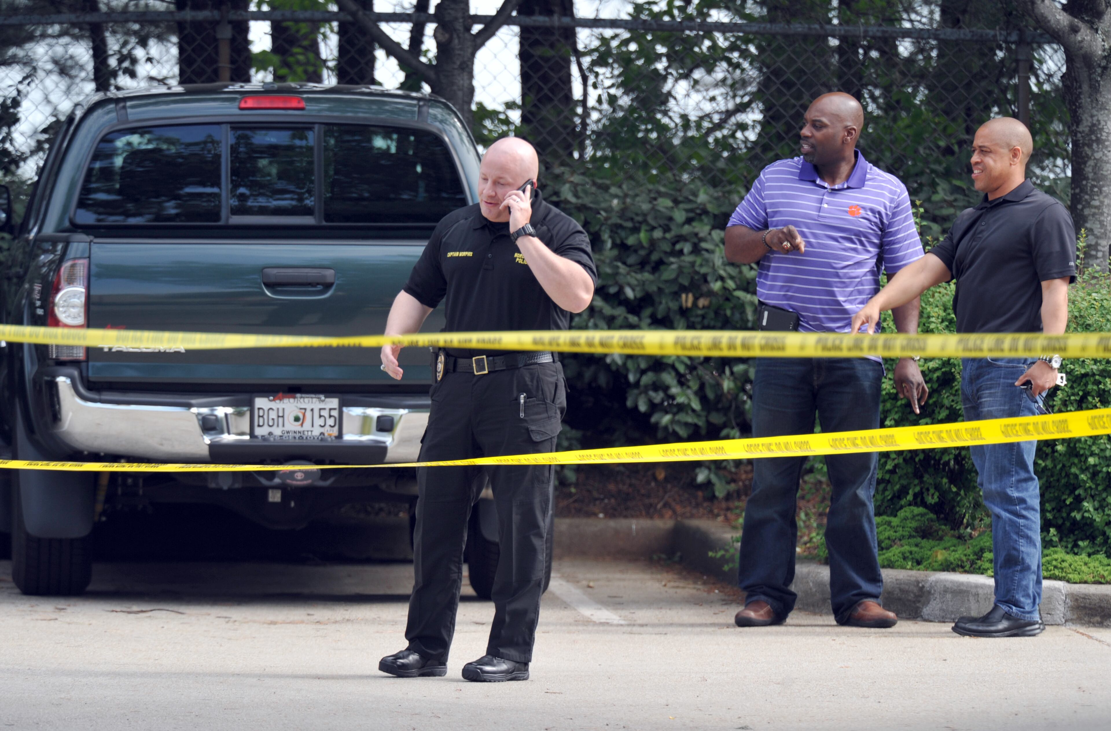 Authorities investigate in the parking lot of Pappadeaux Seafood Kitchen, where at least one victim was shot multiple times, near the intersection of I-85 and Jimmy Carter Boulevard in Norcross on Friday afternoon, May 2, 2014. HYOSUB SHIN / HSHIN@AJC.COM