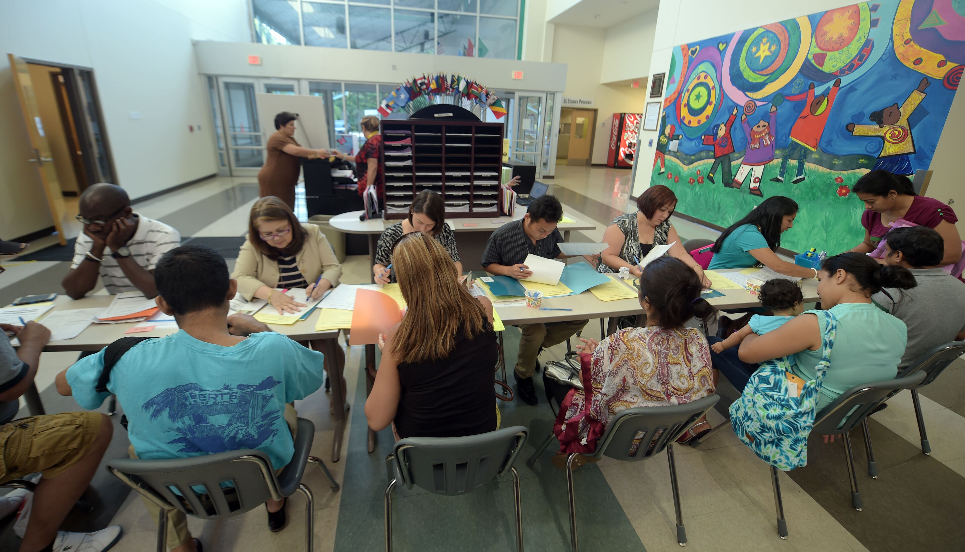 Staff members check information and documents for families trying to register.