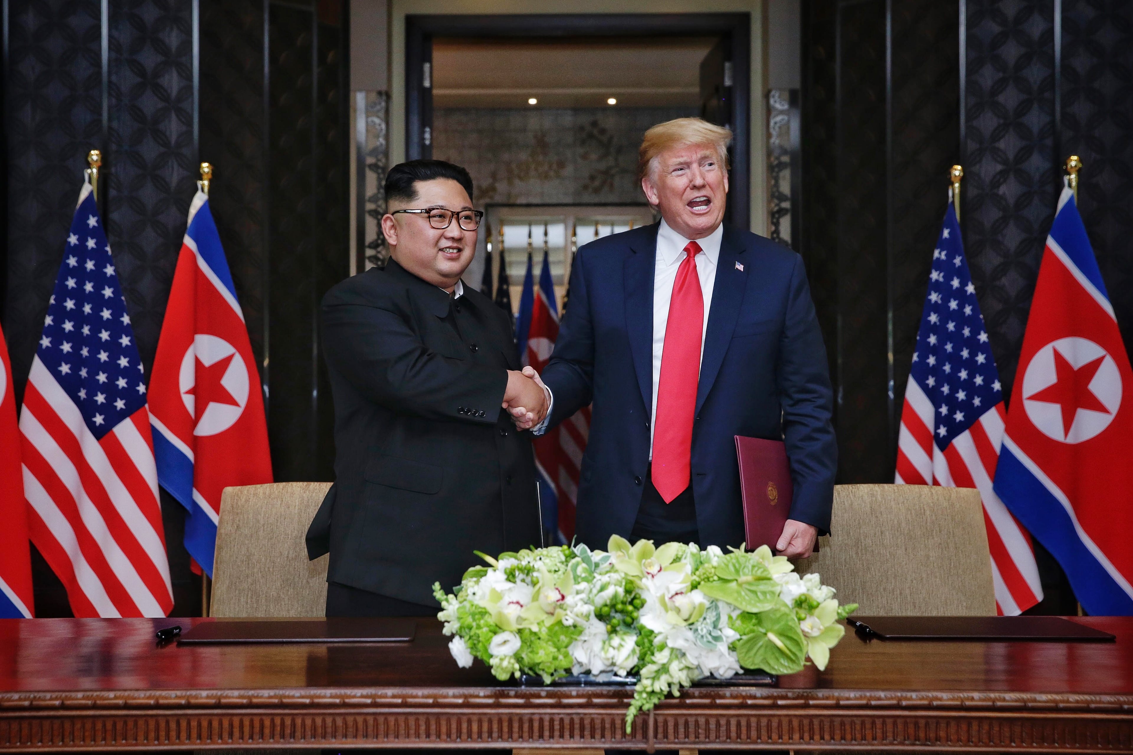 SINGAPORE, SINGAPORE - JUNE 12: In this handout photograph provided by The Strait Times, North Korean leader Kim Jong-un (L) with U.S. President Donald Trump (R) during their historic U.S.-DPRK summit at the Capella Hotel on Sentosa island on June 12, 2018 in Singapore. U.S. President Trump and North Korean leader Kim Jong-un held the historic meeting between leaders of both countries on Tuesday morning in Singapore, carrying hopes to end decades of hostility and the threat of North Korea's nuclear programme. (Photo by Kevin Lim/The Strait Times/Handout/Getty Images)