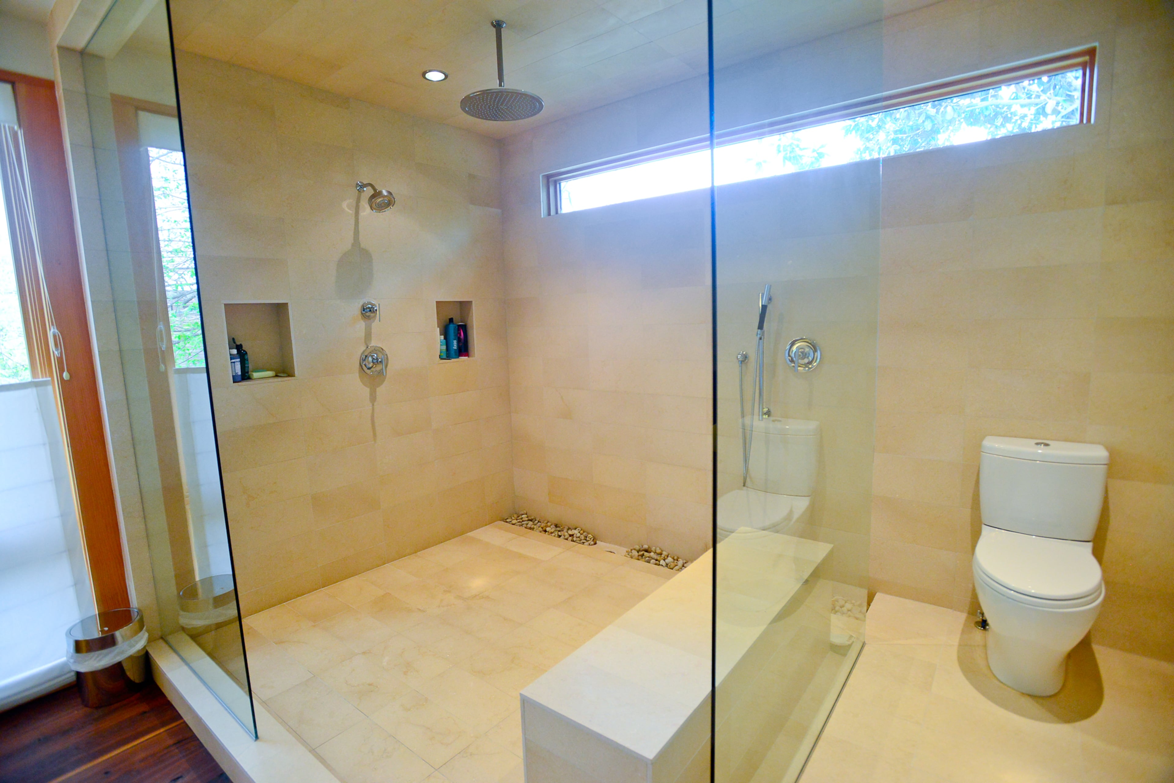 Tile imported from Israel contrasts with the rich tones in the walnut floors in the master bathroom. A horizontal band of windows brings in more light and add to the home's unique design.