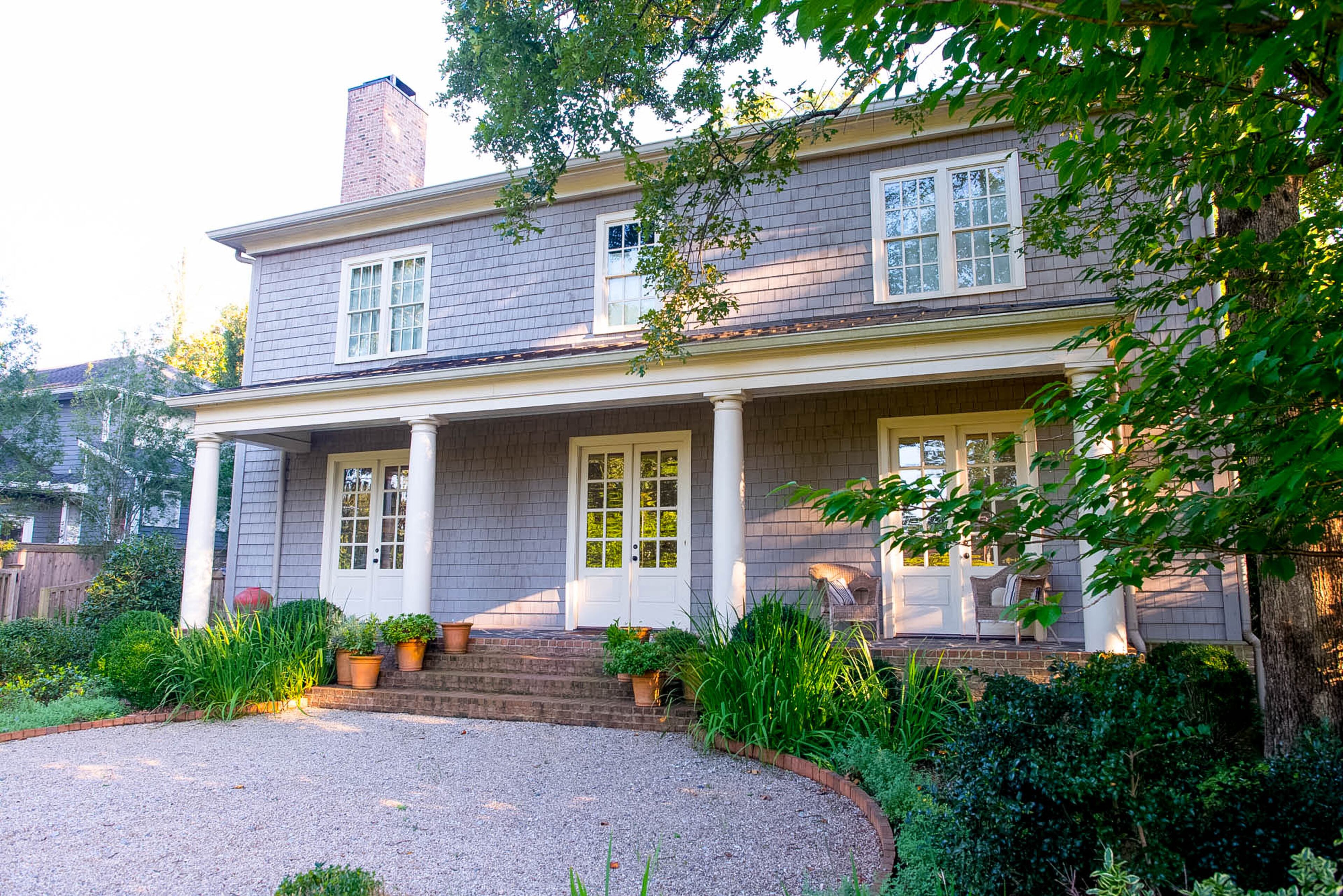 The shingled home has a wide front porch with French doors that invite indoor-outdoor entertaining.