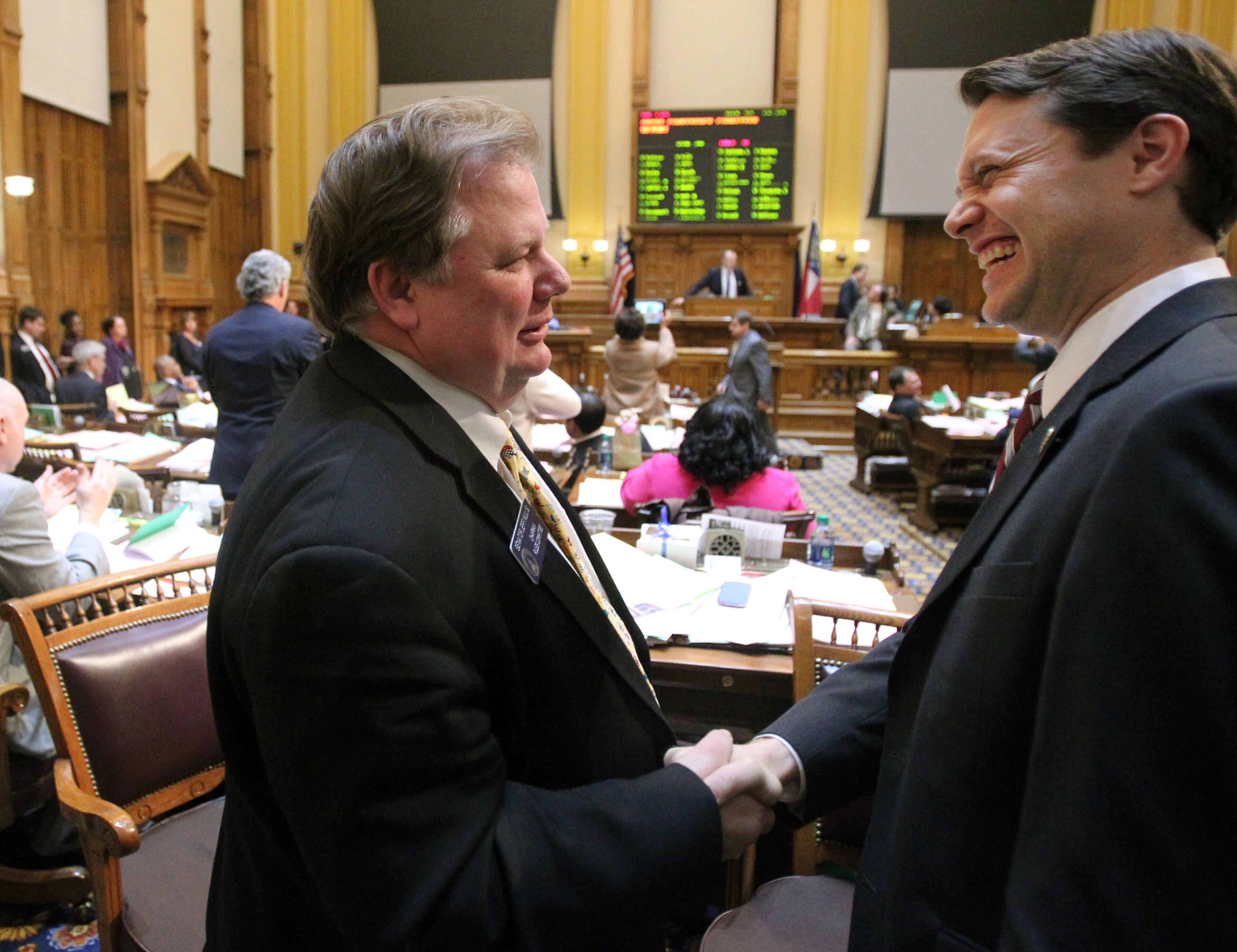 Senate Rules Chairman Jeff Mullis, R-Chickamauga, left, celebrates with Sen. Jason Carter, D-Decatur, after the passing of House Bill 142 during Legislative Day 40 in the Senate Chambers at the Capitol on March 28, 2013.