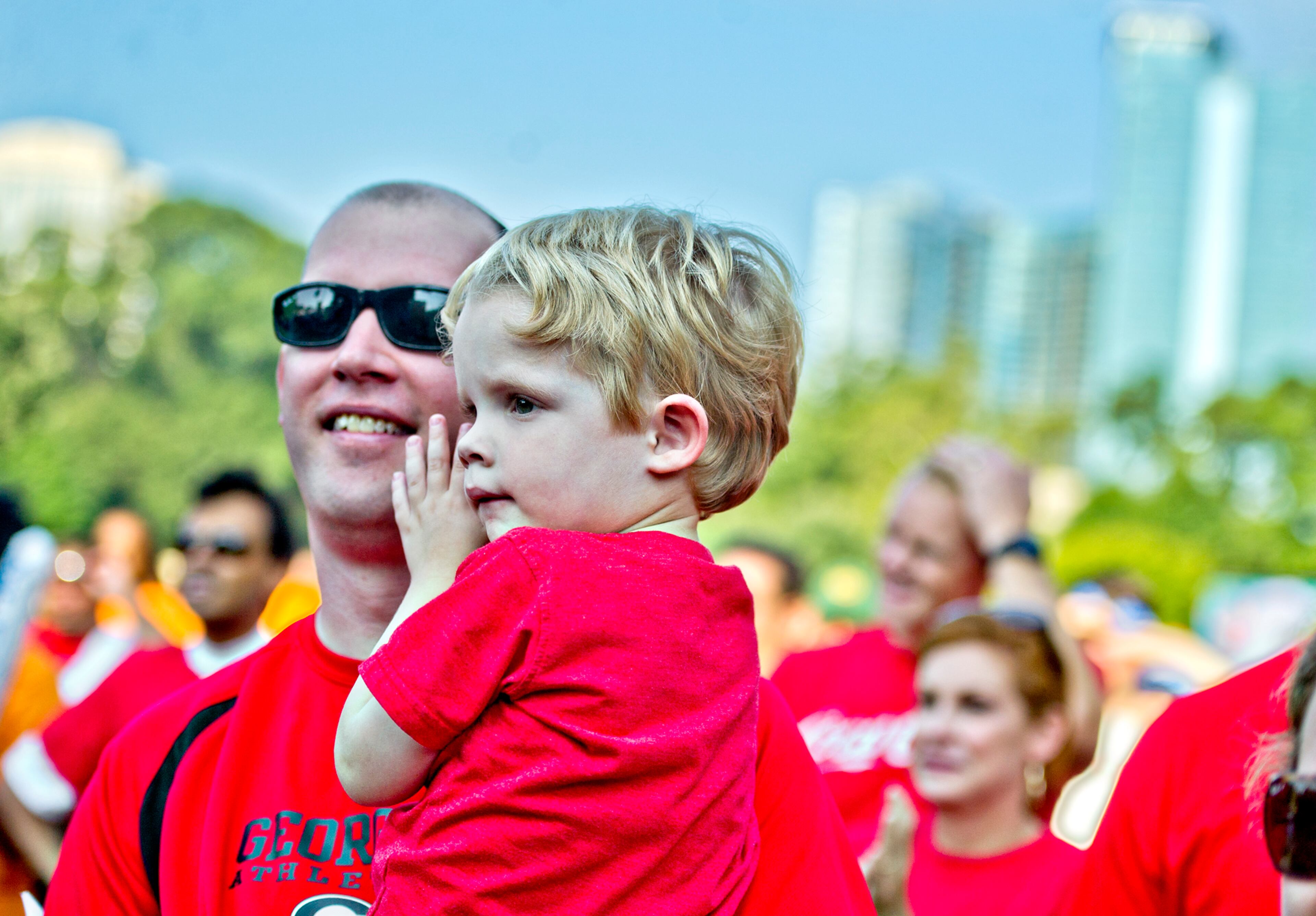 Burke Baker (center) is held by his father Russell during the Boys & Girls Clubs of America's Day for Kids at Piedmont Park in Atlanta on Saturday, September 7, 2013. Day for Kids is a national initiative to raise awareness for critical issues facing young men and women. With more than a decade of tradition, Day for Kids invites adults to act like kids again by participating in field day events such as relay races, dodge ball, tug of war and lots of other activities. JONATHAN PHILLIPS / SPECIAL